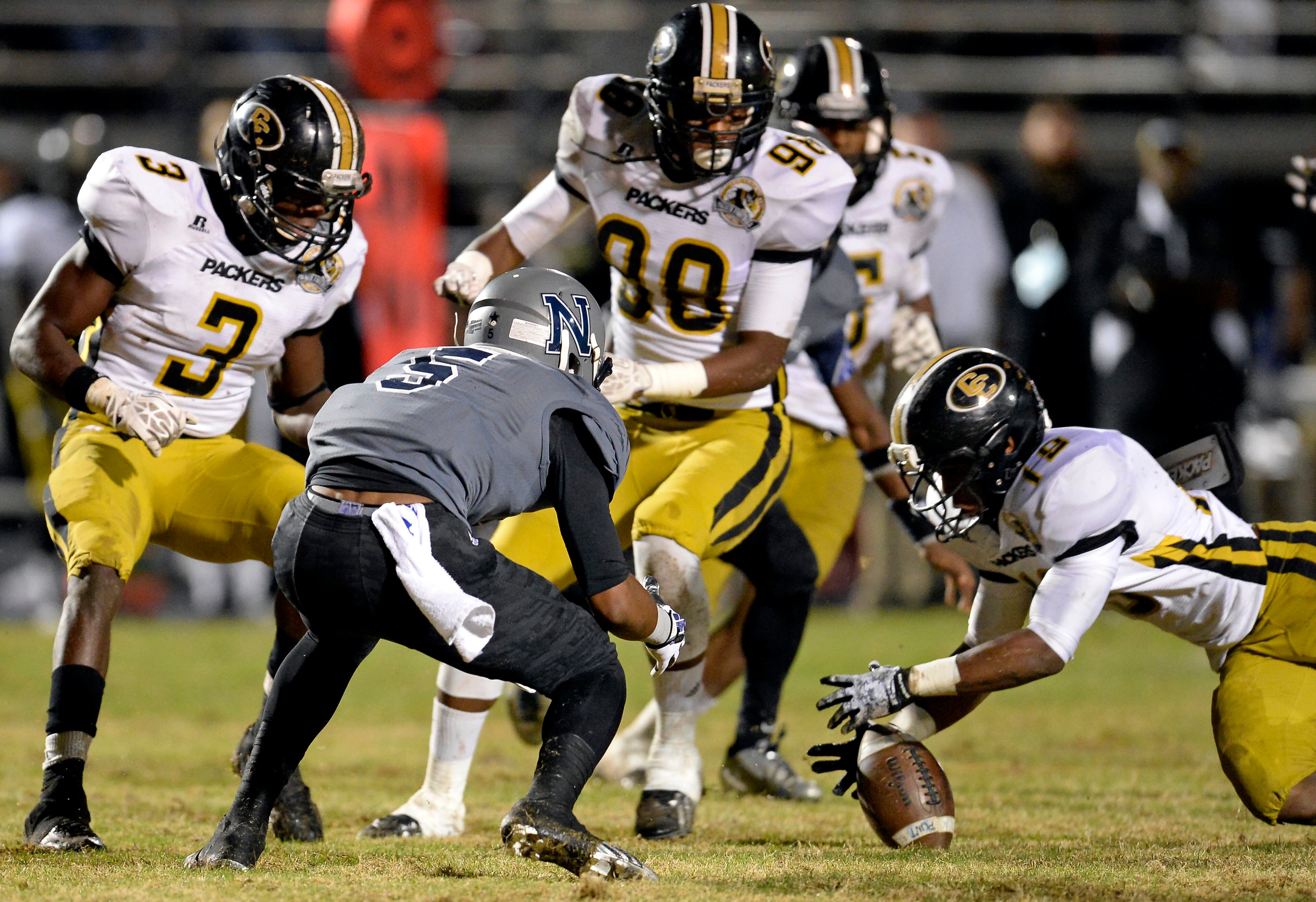 Norcross kick returner Myles Autry (5) fumbles away to Colquitt County's Maleek Lewis (19) on the punt in the first half of their AAAAAA semifinal high school football game at Blue Devil Stadium on Friday, Dec. 6, 2013, in Norcross, Ga.