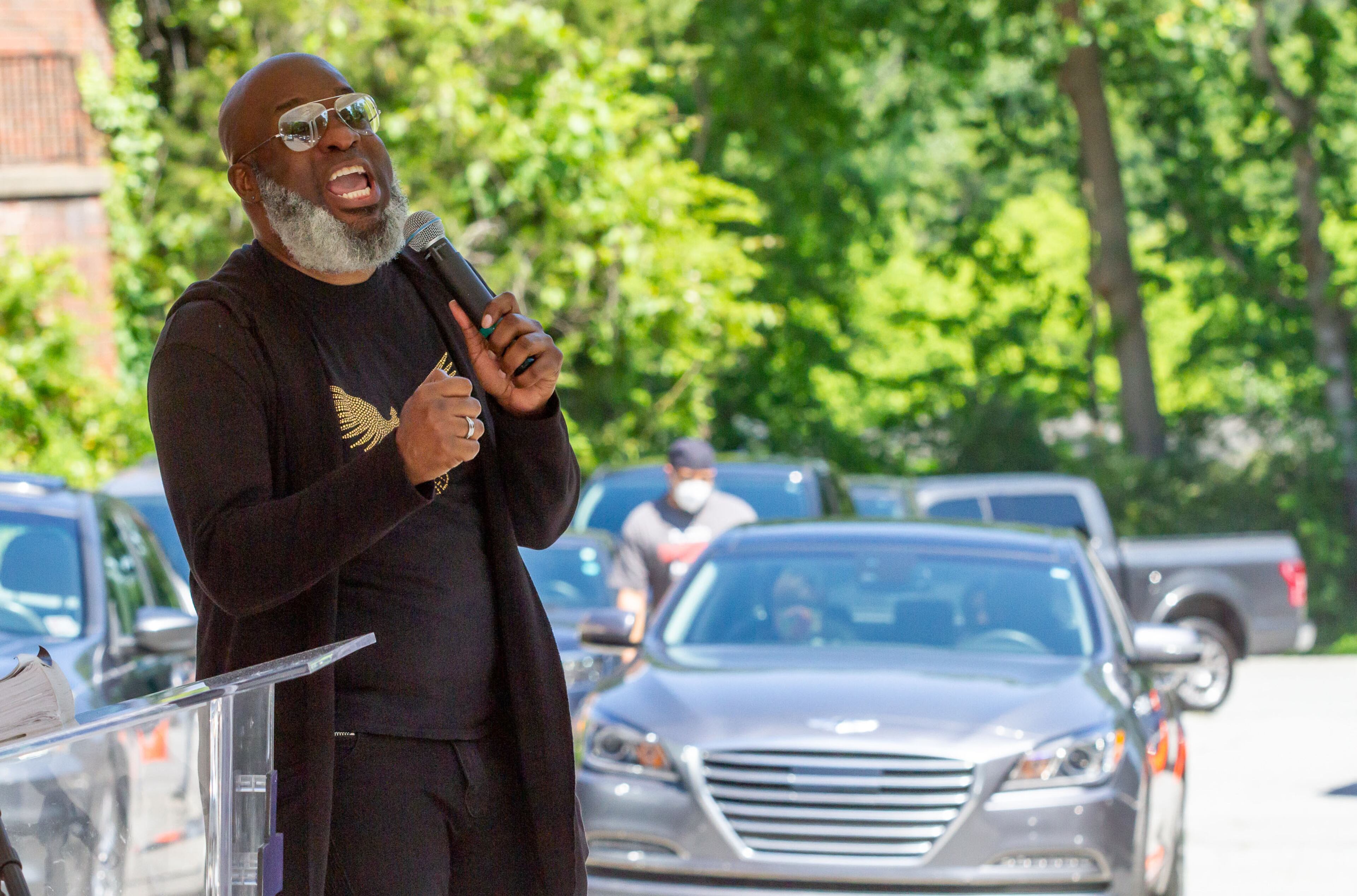 New Beginning Full Gospel Baptist Church Worship Leader Demetrius Banks talks to the church members in their cars during the drive-in Sunday service on May 3, 2020. STEVE SCHAEFER / SPECIAL TO THE AJC