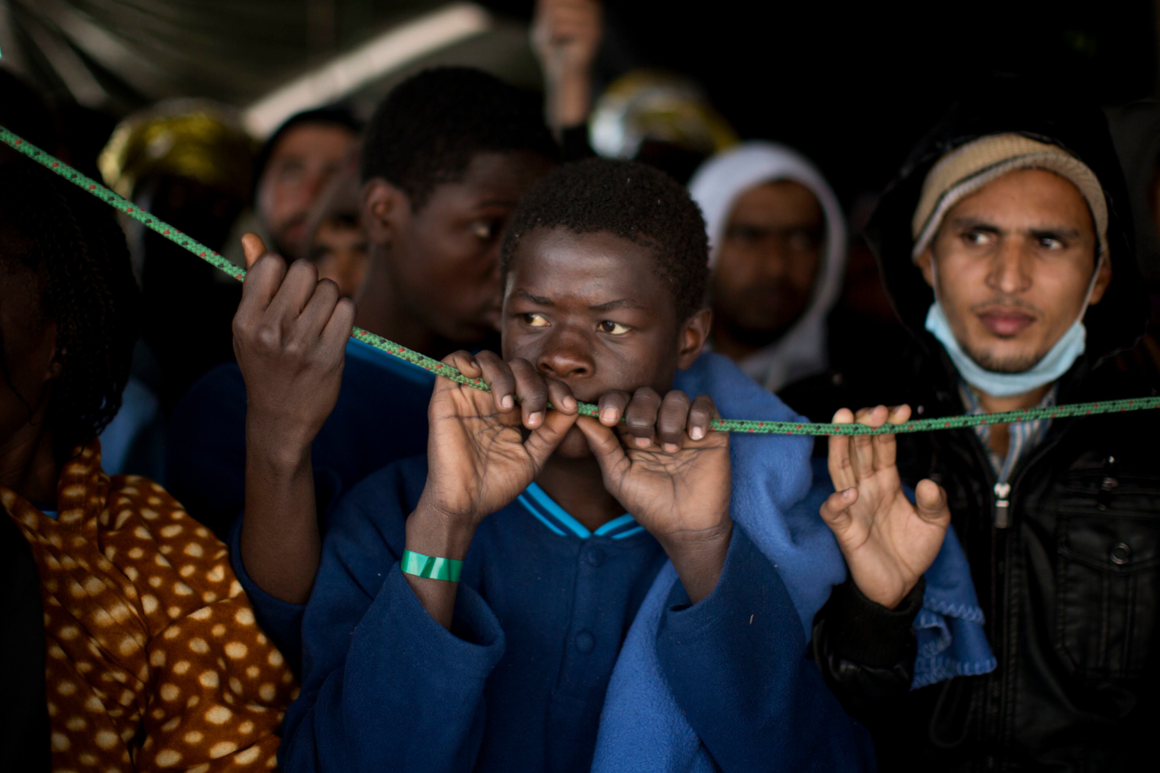 Sub-Saharan migrants wait their turn to leave the Golfo Azzurro rescue vessel after arriving at the port of Pozzallo, south of Sicily, Italy, with more than 220 migrants aboard, rescued by members of Proactive Open Arms NGO, on Sunday, Feb. 5, 2017. Rescuers from different aid organizations pulled more than 1000 people in waters off the Libyan coast on Friday, and all of them were transferred to the Italian authorities. (AP Photo/Emilio Morenatti)