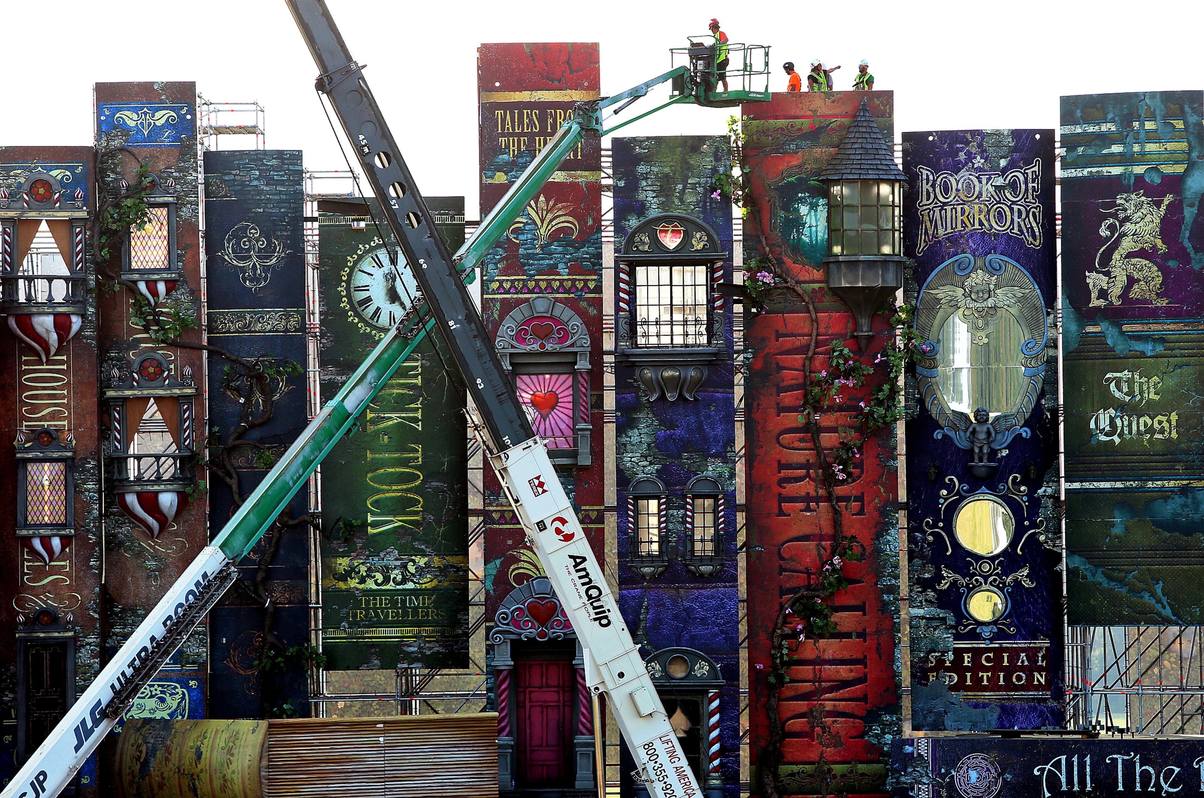 The main stage at the TomorrowWorld Festival site, which is 400 feet wide by 90 feet tall, begins to come together like a row of giant books dwarfing workers on Wednesday, Sept. 18, 2013, in Fairburn.