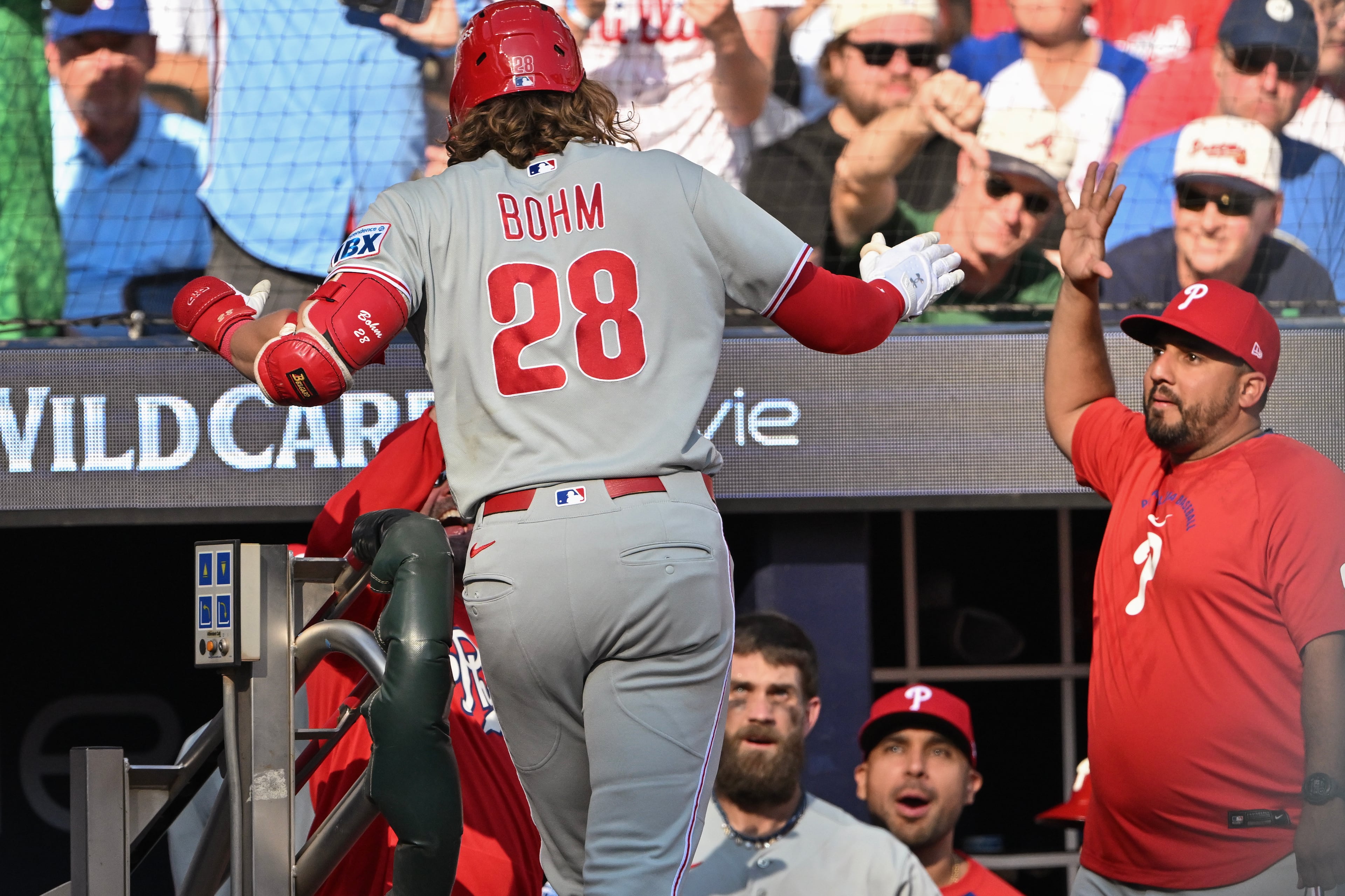 Phillies third baseman Alec Bohm is greeted at the dugout after hitting a solo home run against the Braves during Game 2 of their NL Wild Card Series on Wednesday, Sept. 30, 2026, in Atlanta. (Hyosub Shin/AJC)