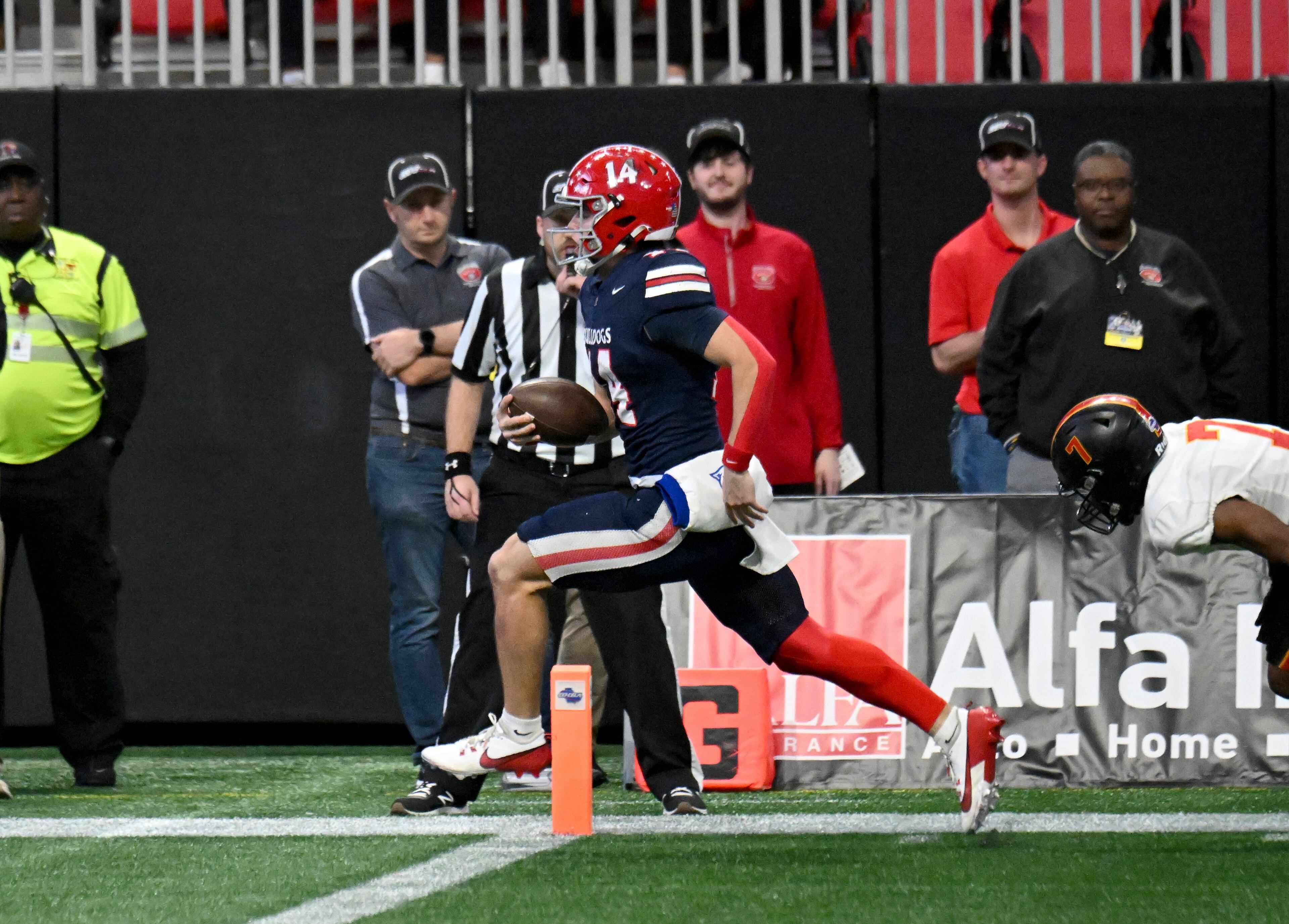 Toombs County's quarterback Tj Stanley (14) scores a touchdown during the fourth quarter in GHSA Class A-Division State Championship game at Mercedes-Benz Stadium, Tuesday, December 17, 2024, in Atlanta. Toombs County won 38-18 over Northeast Macon. (Hyosub Shin / AJC)
