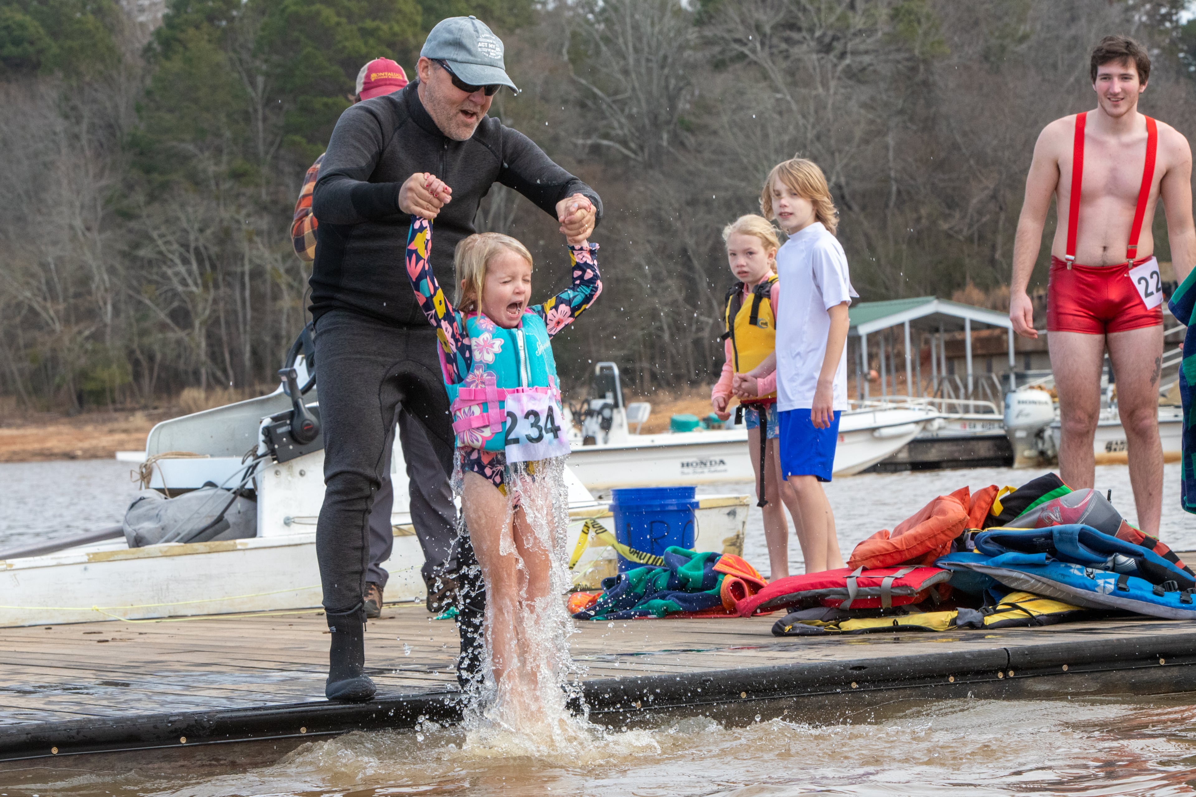 Choosing a dunk rather than a quick swim, 6-year-old Emery Ellison, visiting from Texas, participates in the 26th annual Polar Bear Paddle and Plunge at Lake Lanier Olympic Park on Monday, Jan 1, 2024. (Jenni Girtman for The Atlanta Journal-Constitution)