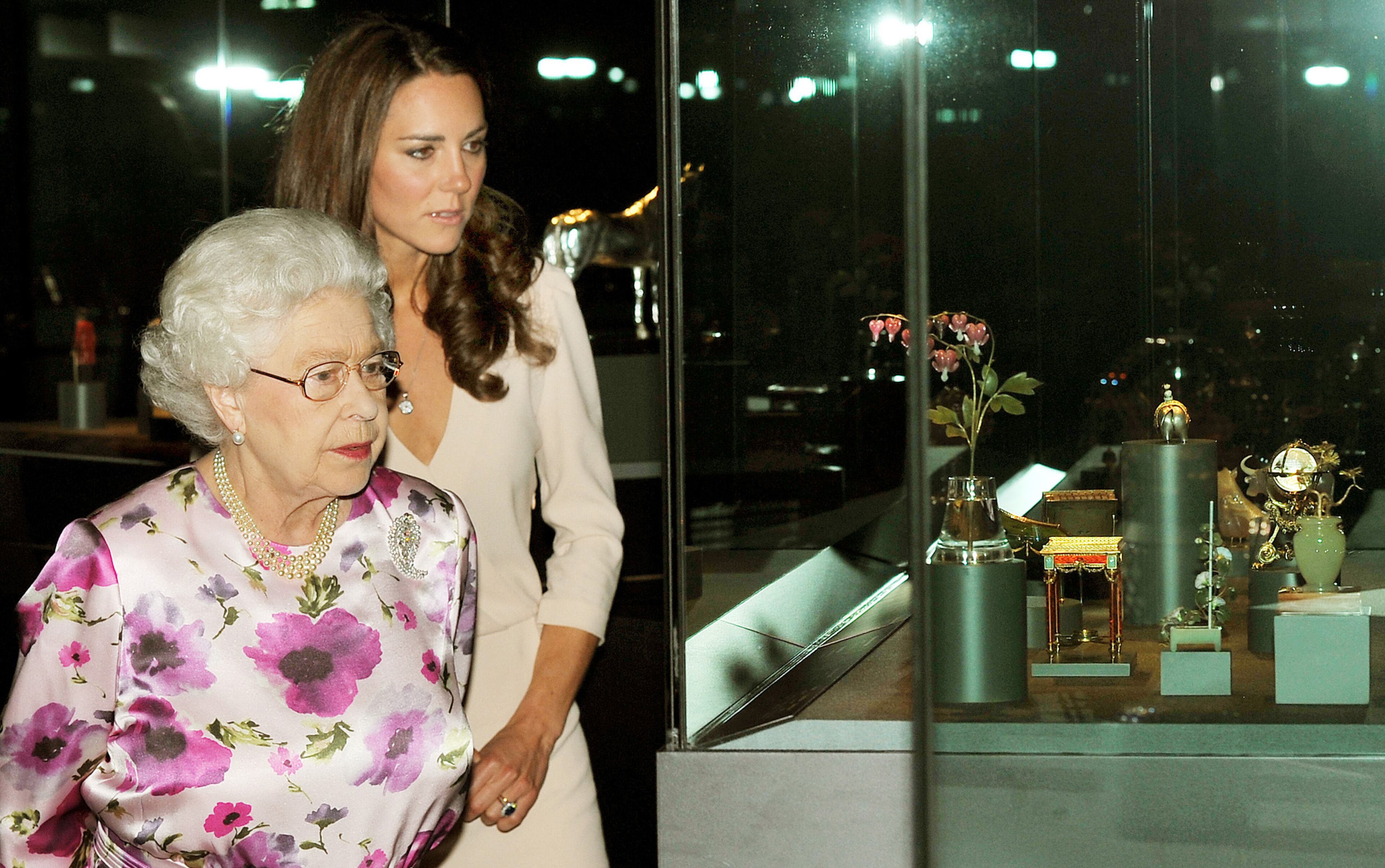 LONDON, UNITED KINGDOM - JULY 22: Britain's Queen Elizabeth II and Catherine, Duchess of Cambridge view the exhibitions for the summer opening of Buckingham Palace on July 22, 2011 in London, England. The Duchess of Cambridge's intricately decorated wedding dress, designed by Sarah Burton of Alexander McQueen is currently on display at Buckingham Palace (Photo by John Stillwell - WPA Pool/Getty Images)