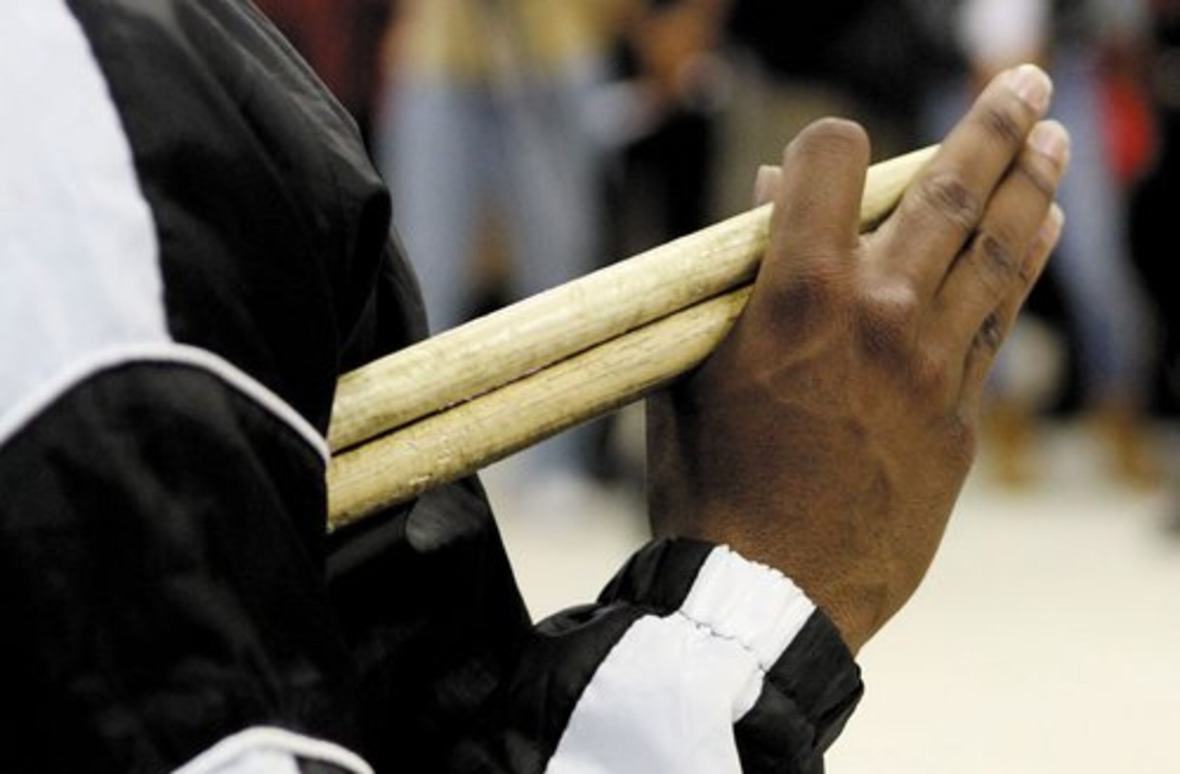 Drum corps member Amir Henry holds his drum sticks.