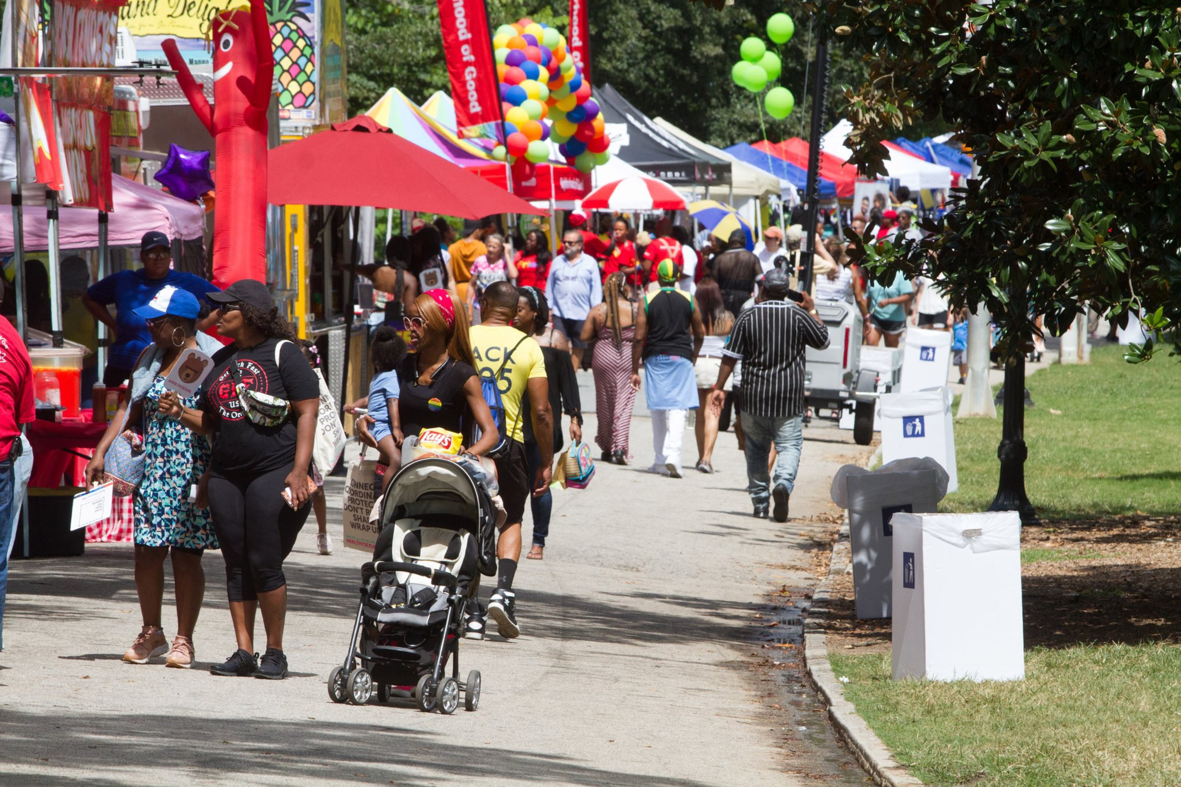 People walk past the vendor booths during the Pure Heat Community Festival celebrating Atlanta Black Pride Weekend. STEVE SCHAEFER / SPECIAL TO THE AJC