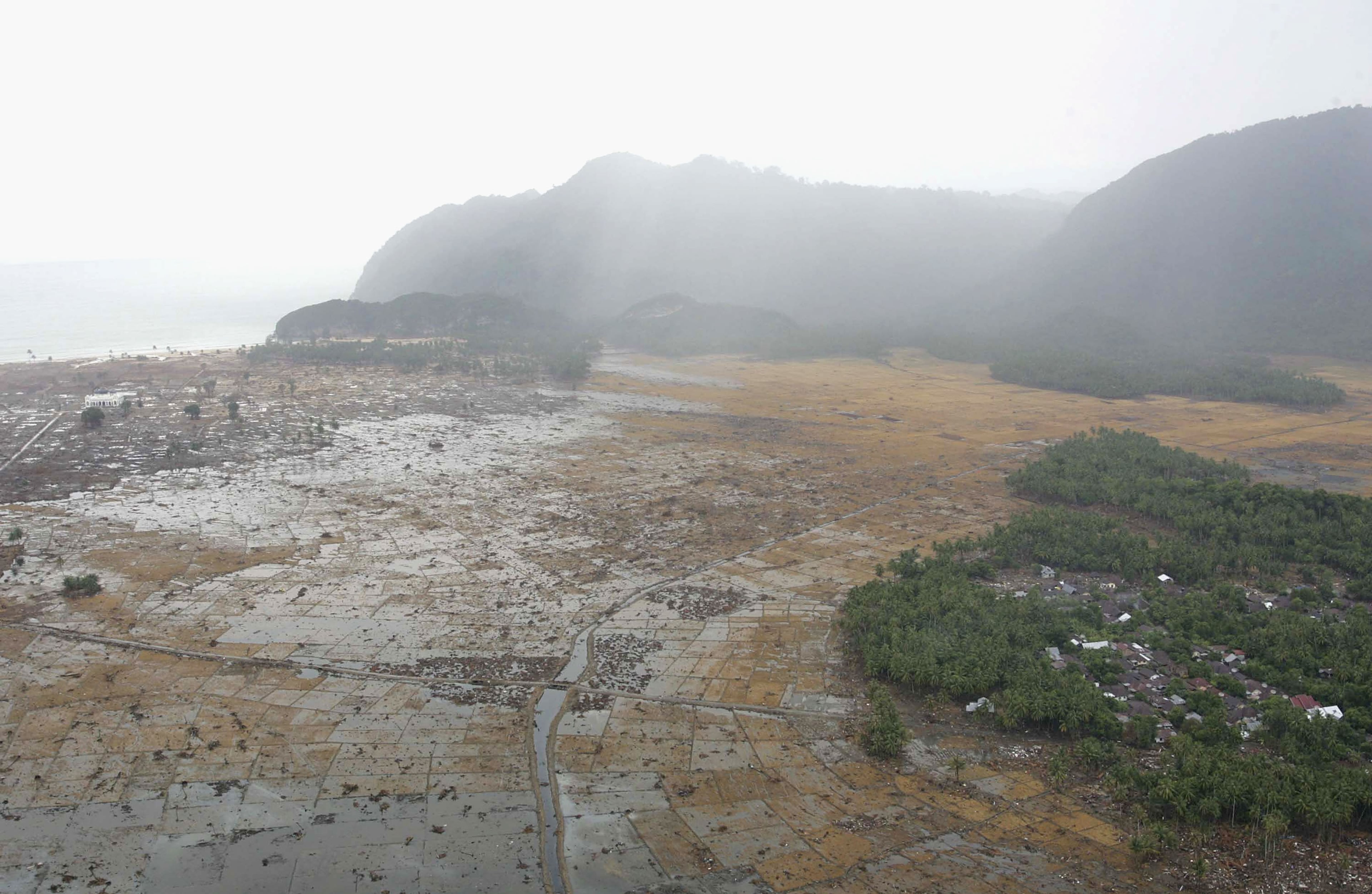ACEH, INDONESIA - JANUARY 8, 2005: An aerial shot taken from a US Navy Seahawk helicopter from carrier USS Abraham Lincoln shows devastation caused by the Indian Ocean tsunami to the west of Aceh on January 8, 2005 in Banda Aceh, Indonesia. Indonesia, Thailand and Sri Lanka are the countries most affected by the December 26 earthquake-tsunami disaster. (Photo by Dimas Ardian/Getty Images)