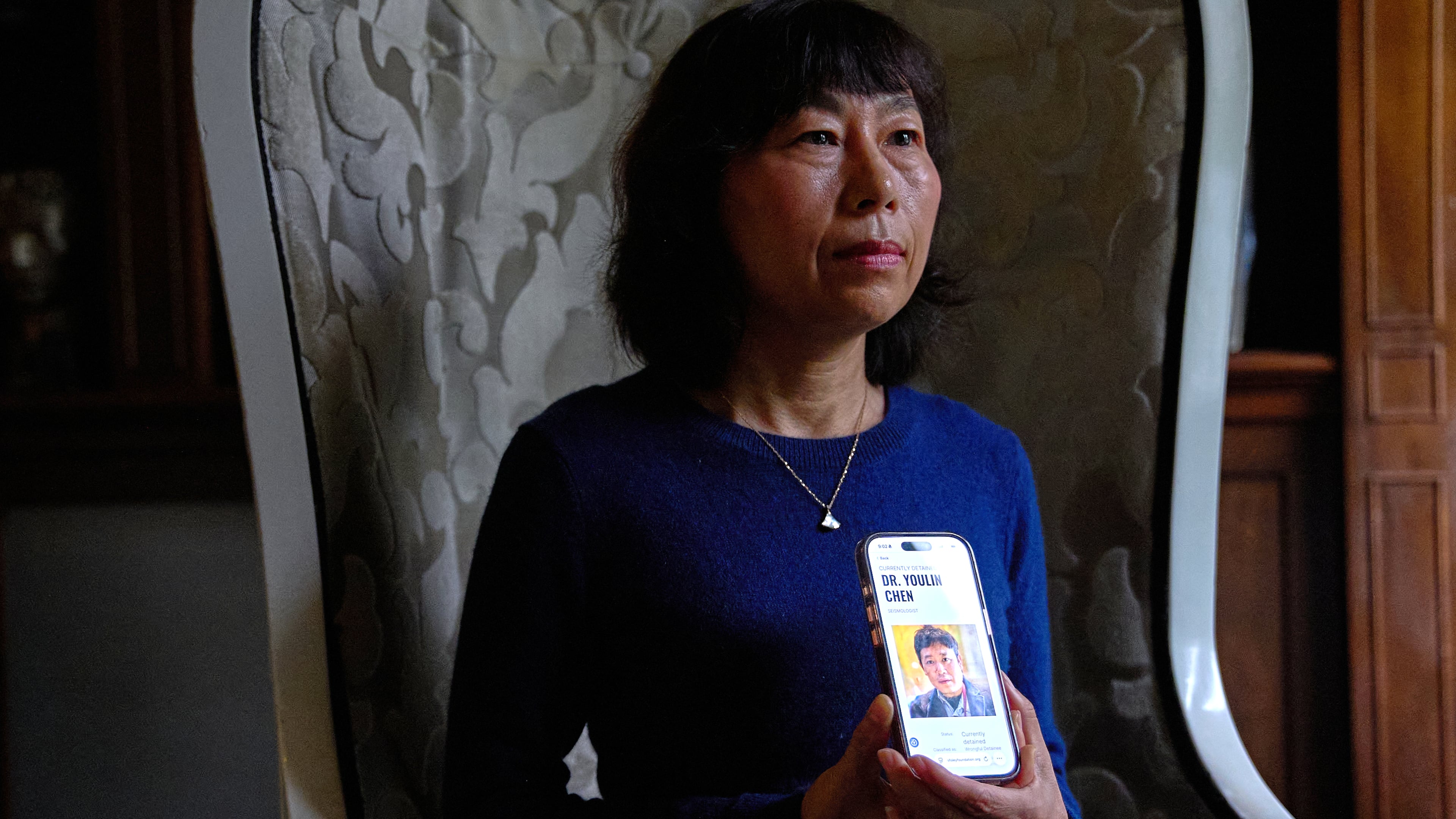 Yufang Rong, wife of U.S. citizen Youlin Chen, who she says has been wrongfully detained in China, holds a photograph of him as seen on a website about detainees on her phone, during an interview, Tuesday, Sept. 22, 2026, in Washington. (AP Photo/Jacquelyn Martin)