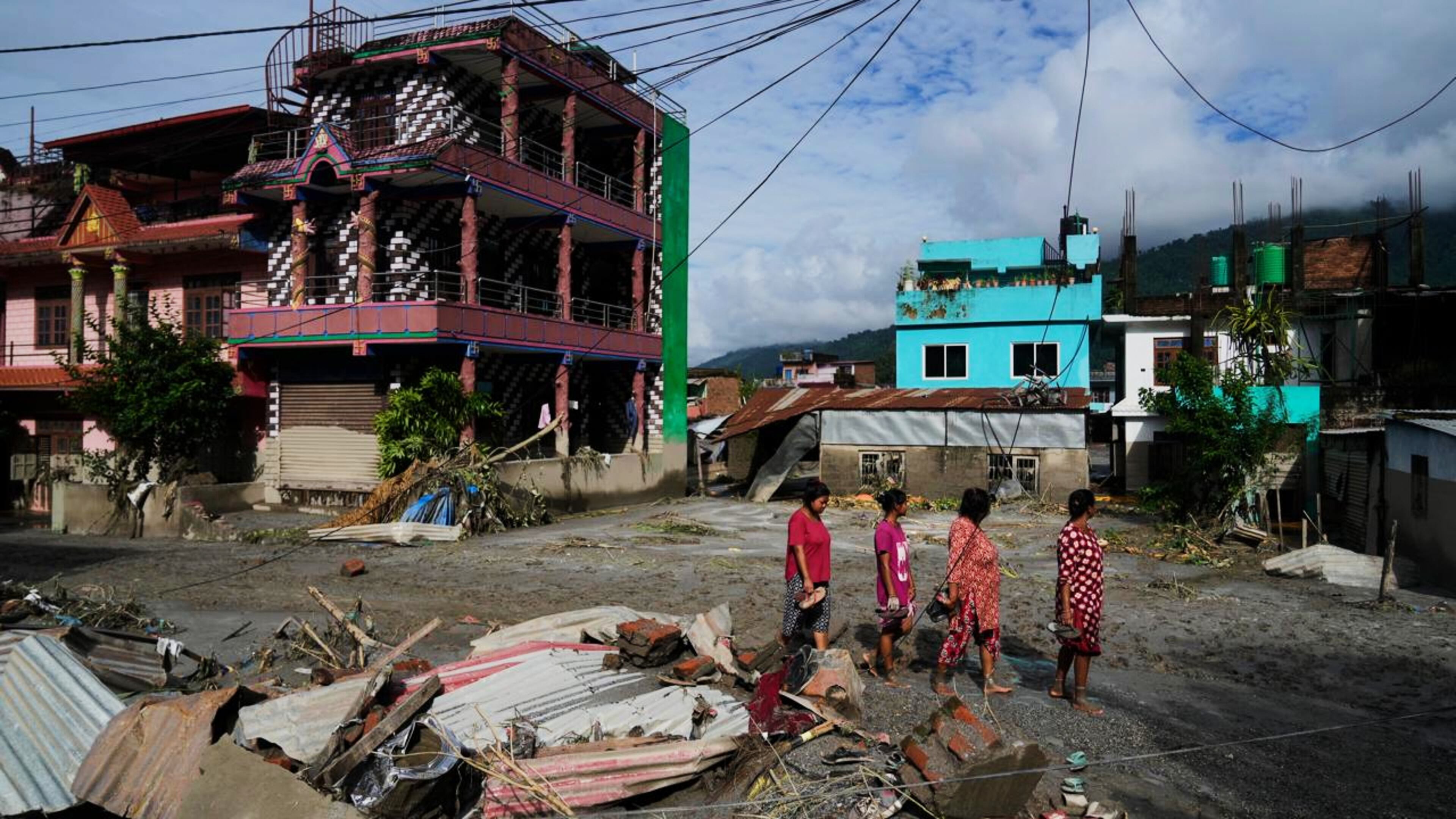 People walk past damage in the aftermath of flash floods in Devighat in the Nuwakot district in Nepal, Thursday, Aug 27, 2026. (AP Photo/Niranjan Shrestha)