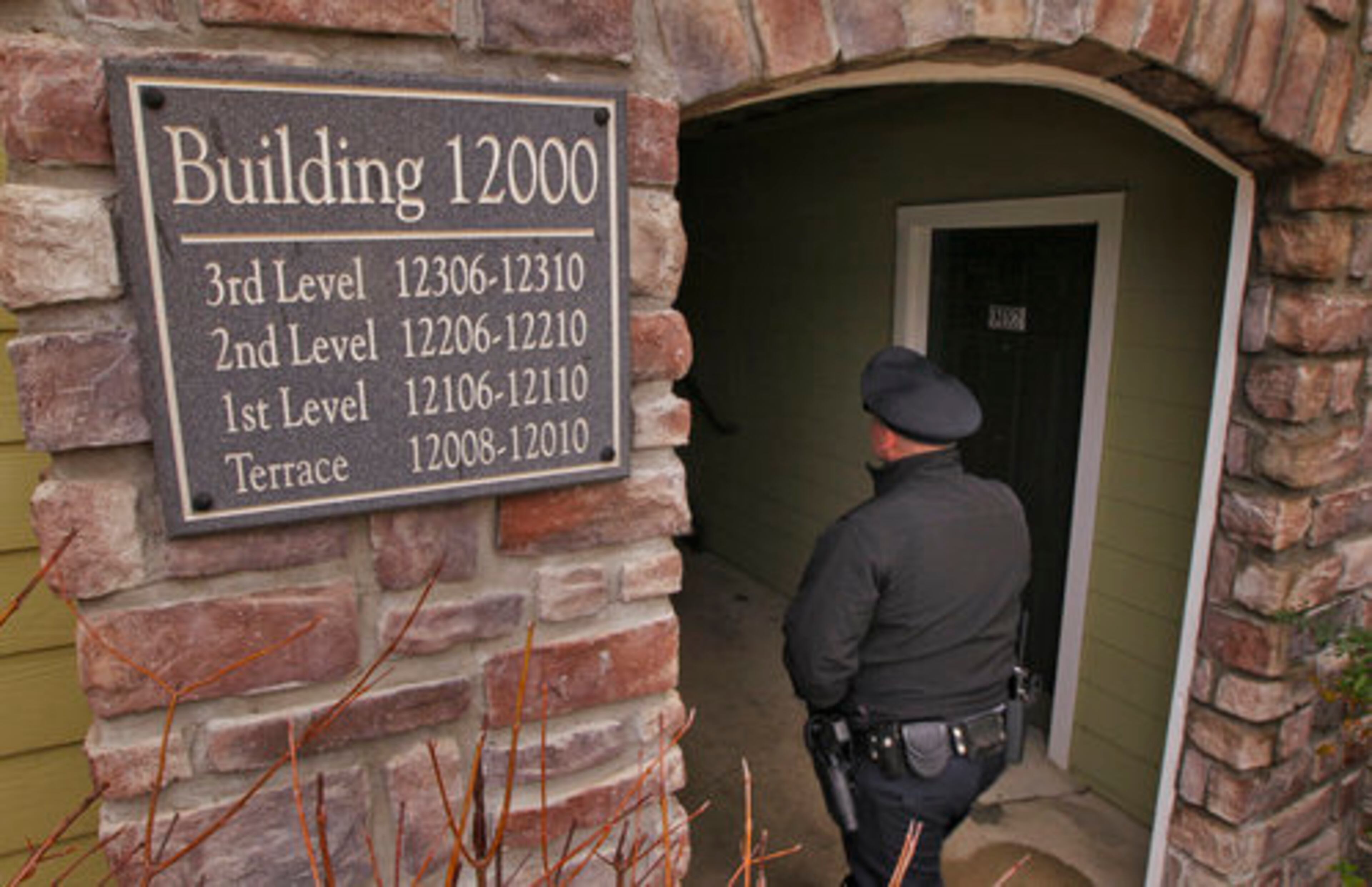 A Canton police officer enters the breezeway to the building where Brunn lived.