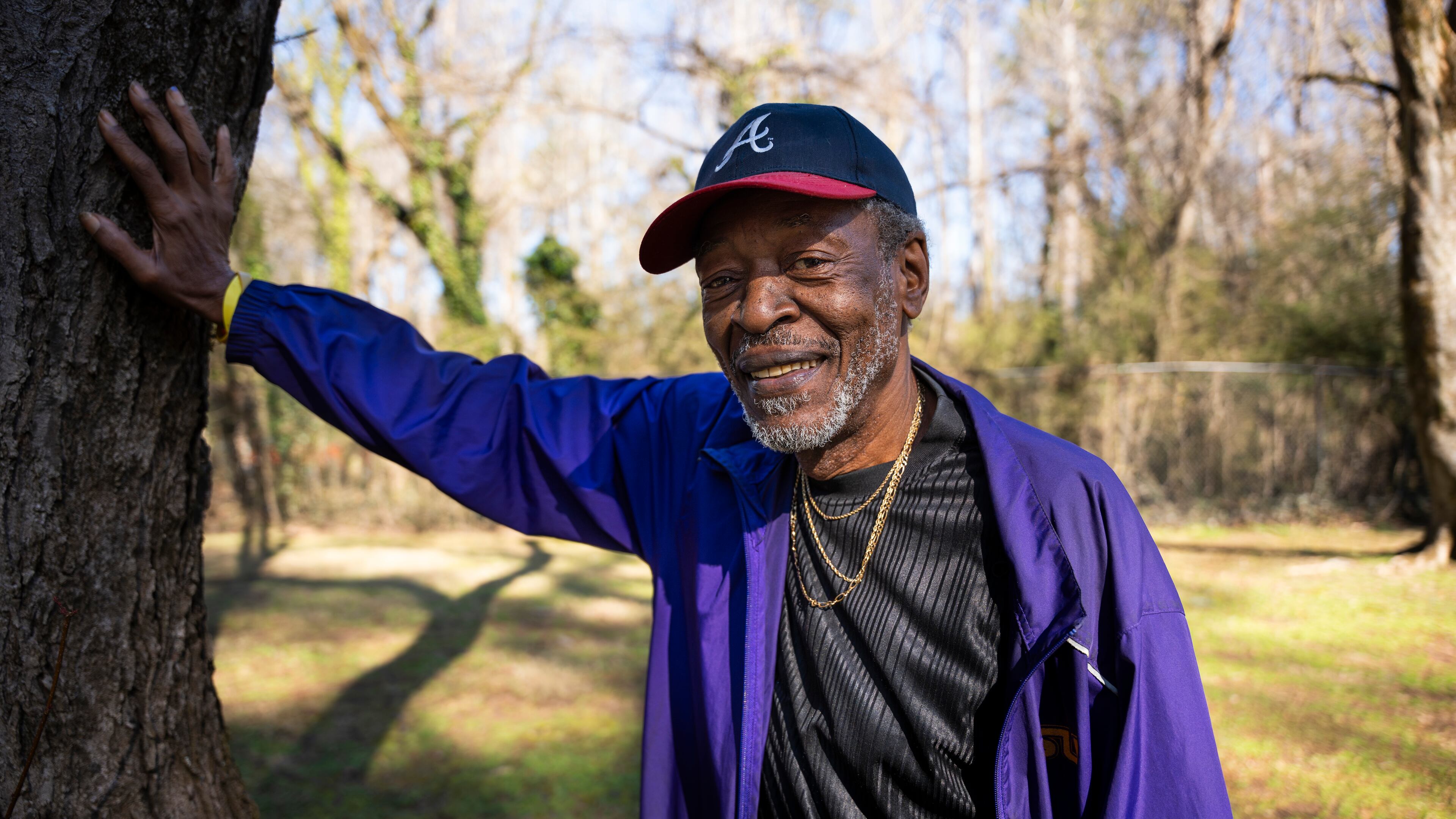 Fernando Jones touches the tree he fell from as a child at the site of the old Carrie Steele-Pitts Home in Atlanta, Georgia on Monday, Feb, 3, 2025. (Olivia Bowdoin for the AJC).