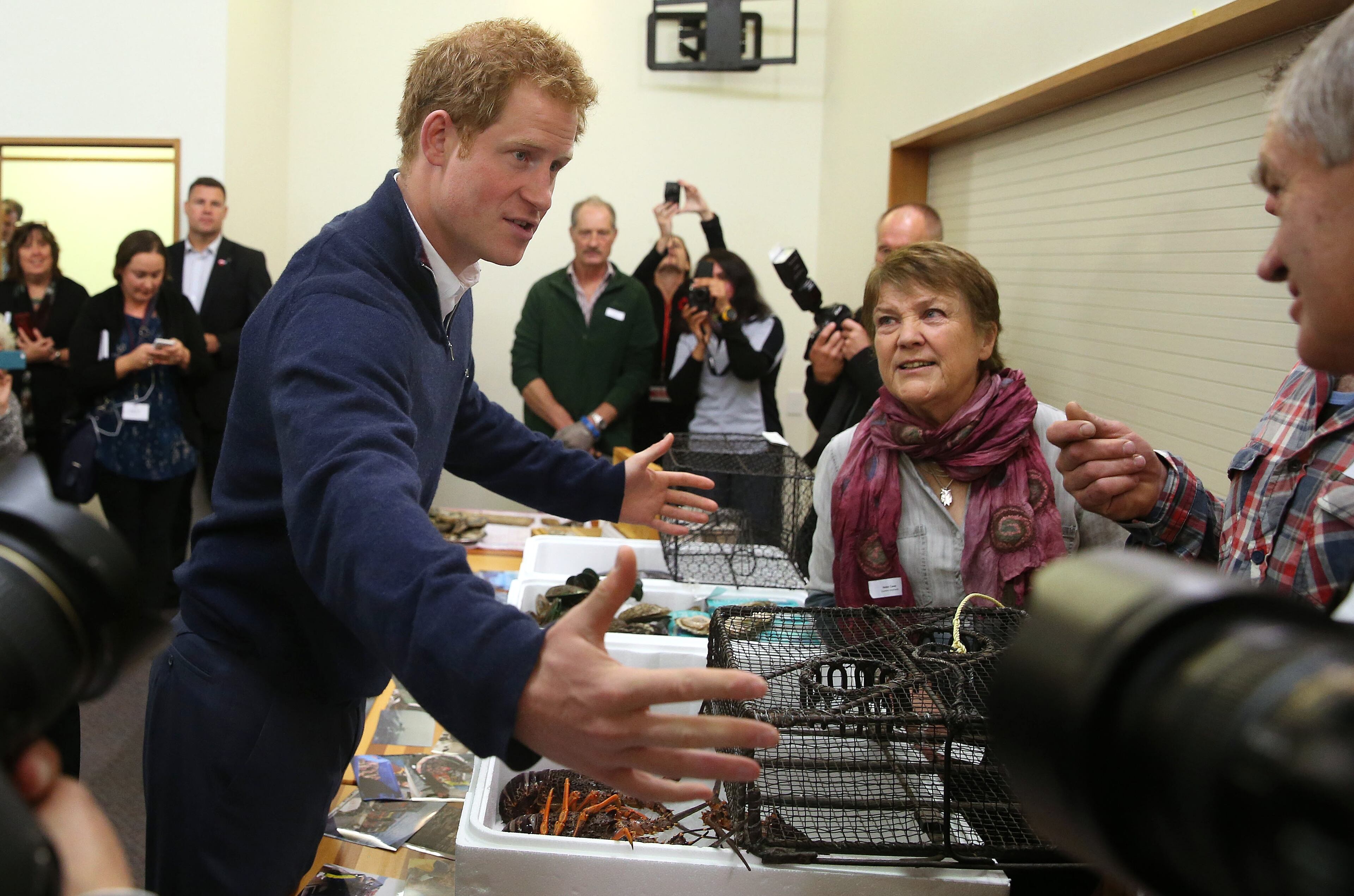 Britain's Prince Harry, center, visits the Stewart Island Community Centre as part of his first visit to New Zealand, on May 10, 2015.