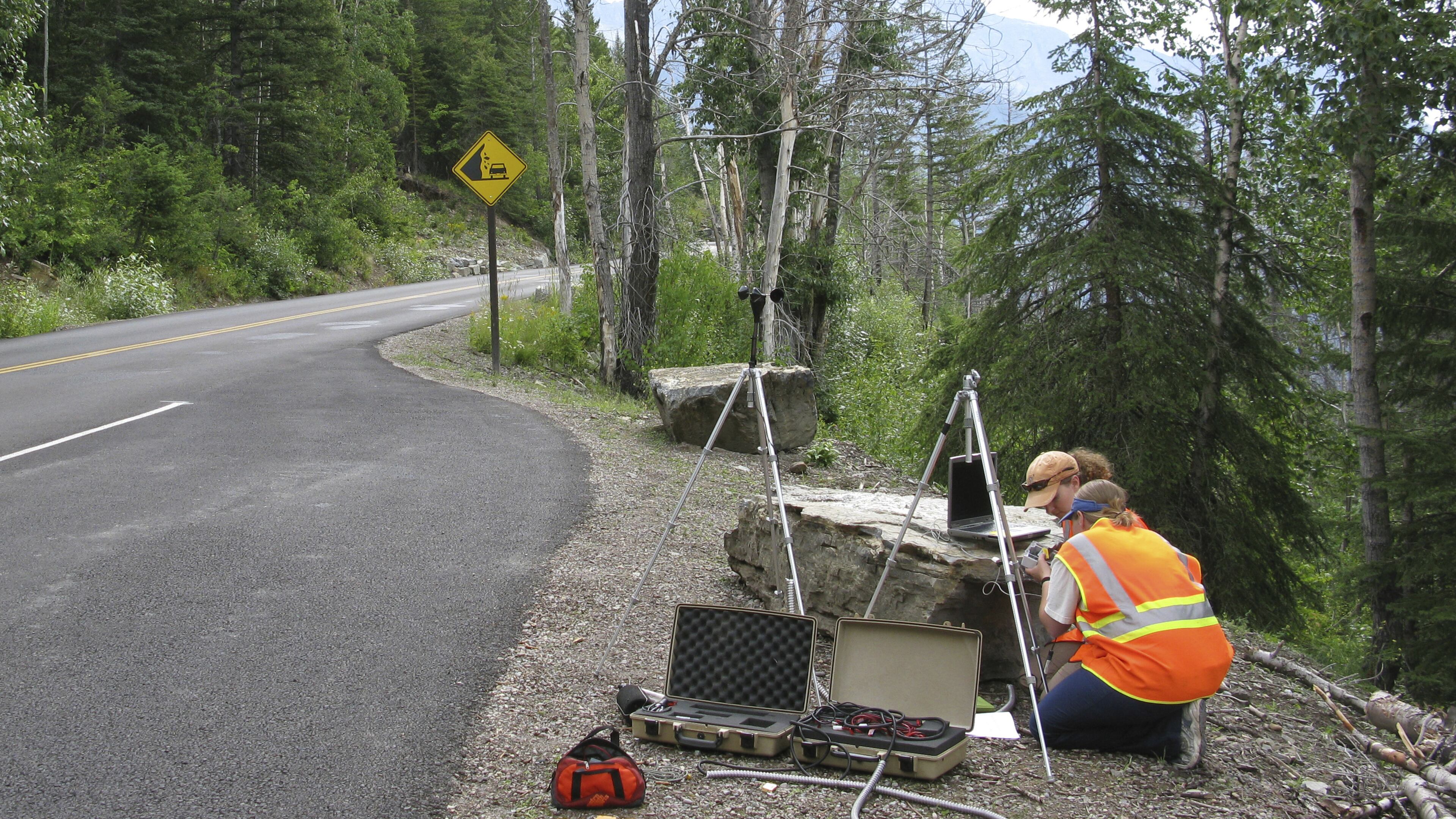 In this photo provided by the National Park Service a National Park Service staffer sets up an acoustic recording station on Going-to-the-Sun Road to capture the impact of traffic on acoustic conditions in Glacier National Park, Mont. The call of the wild is getting harder to hear. Peaceful natural sounds, bird songs, rushing rivers and rustling grass, are being drowned out by human-made noise in nearly two-thirds of Americaâs protected parks, forests and wilderness areas, a new study finds. (National Park Service via AP)