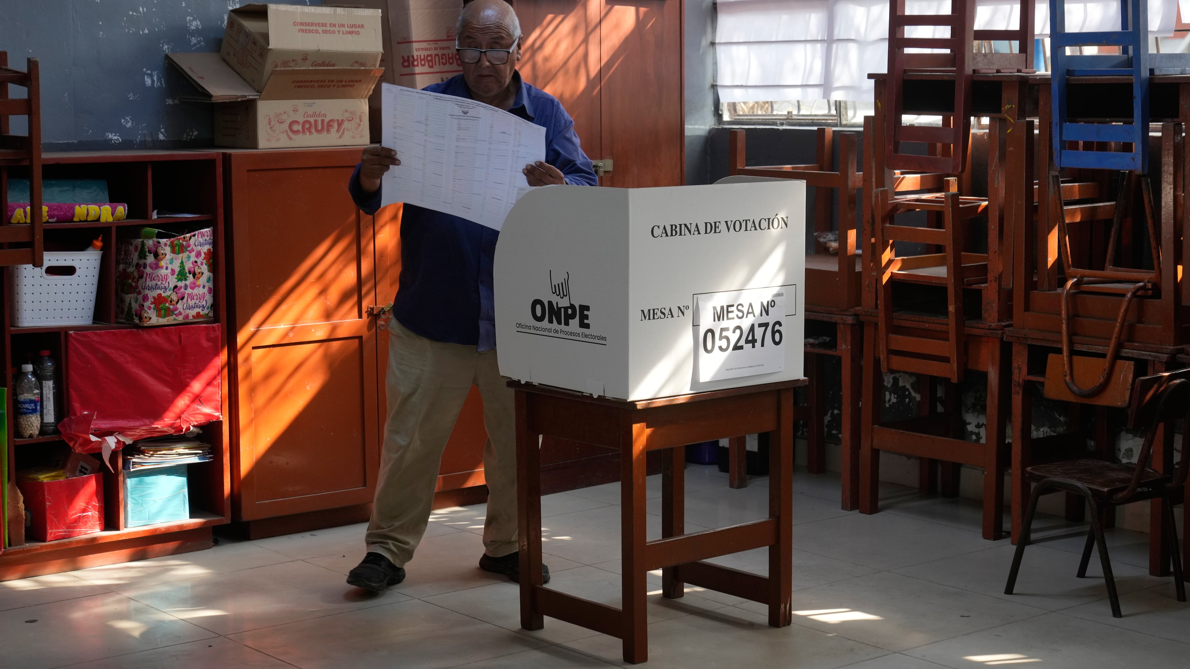 A voter looks at a ballot before marking his candidates during general elections in Lima, Peru, on Sunday, April 12, 2026. (AP Photo/Martin Mejia)