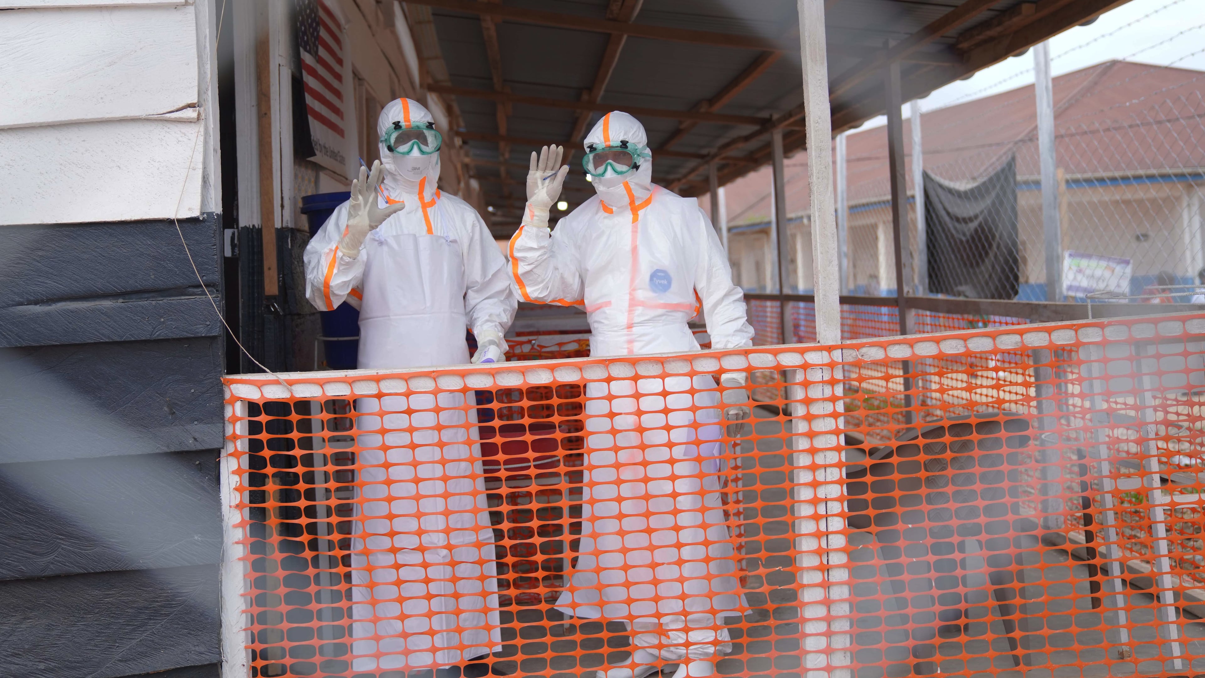 Health workers in protective gear wave inside an Ebola treatment centre in Bunia, Congo, Monday, Aug. 10, 2026. (AP Photo/Dieudonne Dirole)
