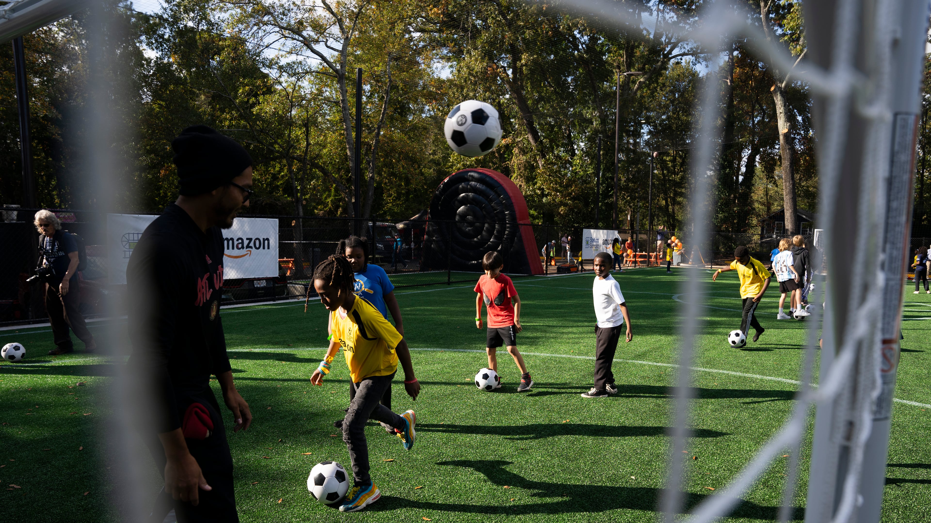 Kids play on Soccer in the Streets' field at the East Lake MARTA Station in Atlanta on Oct, 27, 2023. Sports marketing executive Vince Thompson is buying tickets for a small number of youngsters from the program and their chaperones to attend a World Cup game June 24. (Olivia Bowdoin for the AJC)