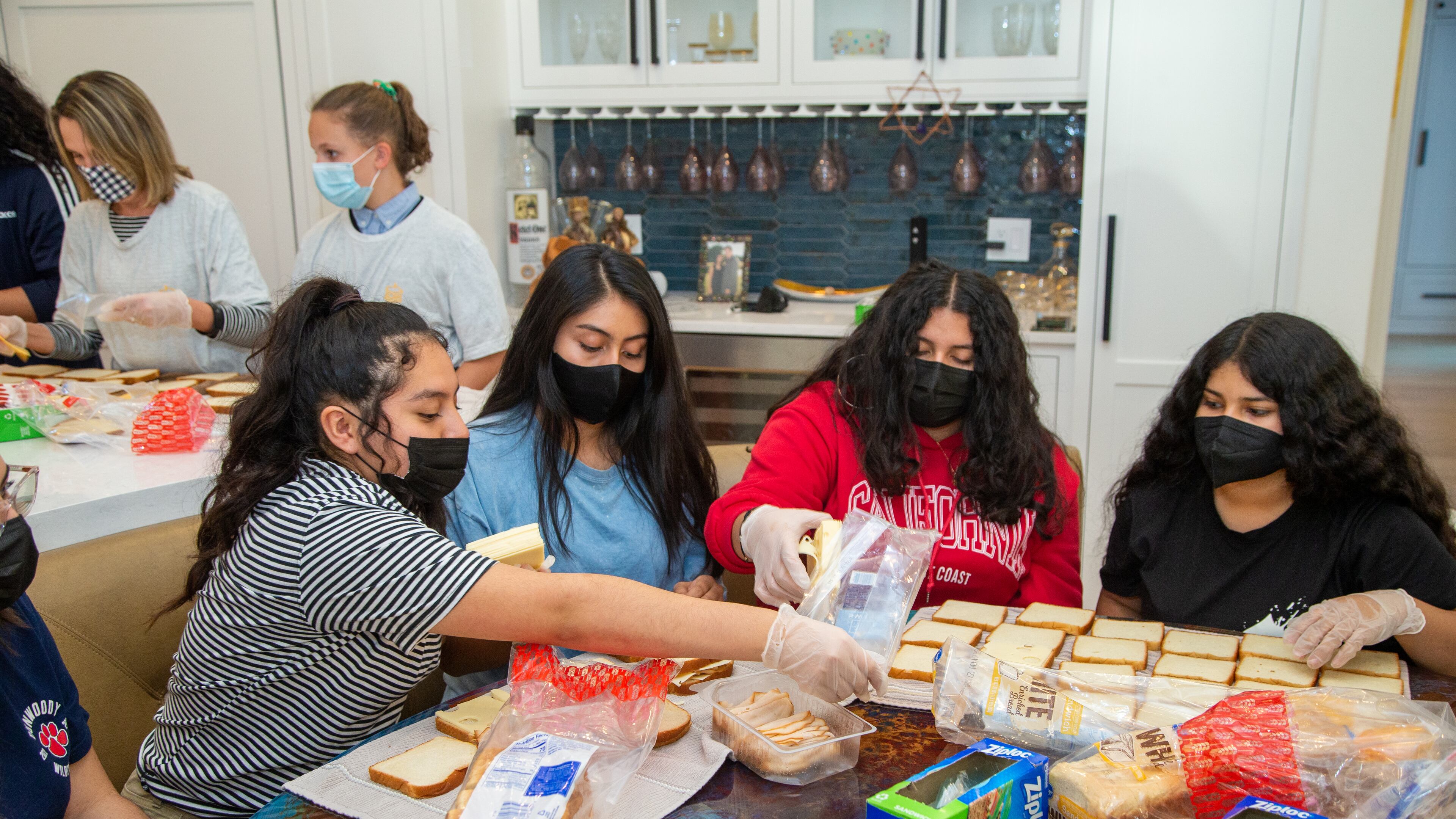 Geovanna Rodas (from left), Mary Avecillas, Victoria Cardenas and Raquel Espinoza work together at Marcy Louza's Dunwoody home making sandwiches for The Sandwich Project. Two ladies from Dunwoody started making sandwiches for the homeless during the pandemic and this project has expanded into a weekly community service project involving thousands of volunteers all over the metro area. Every week, The Sandwich Project gives away approximately 4,000 to 6,000 sandwiches, plus snacks and fruit to nonprofits for distribution. PHIL SKINNER FOR THE ATLANTA JOURNAL-CONSTITUTION.