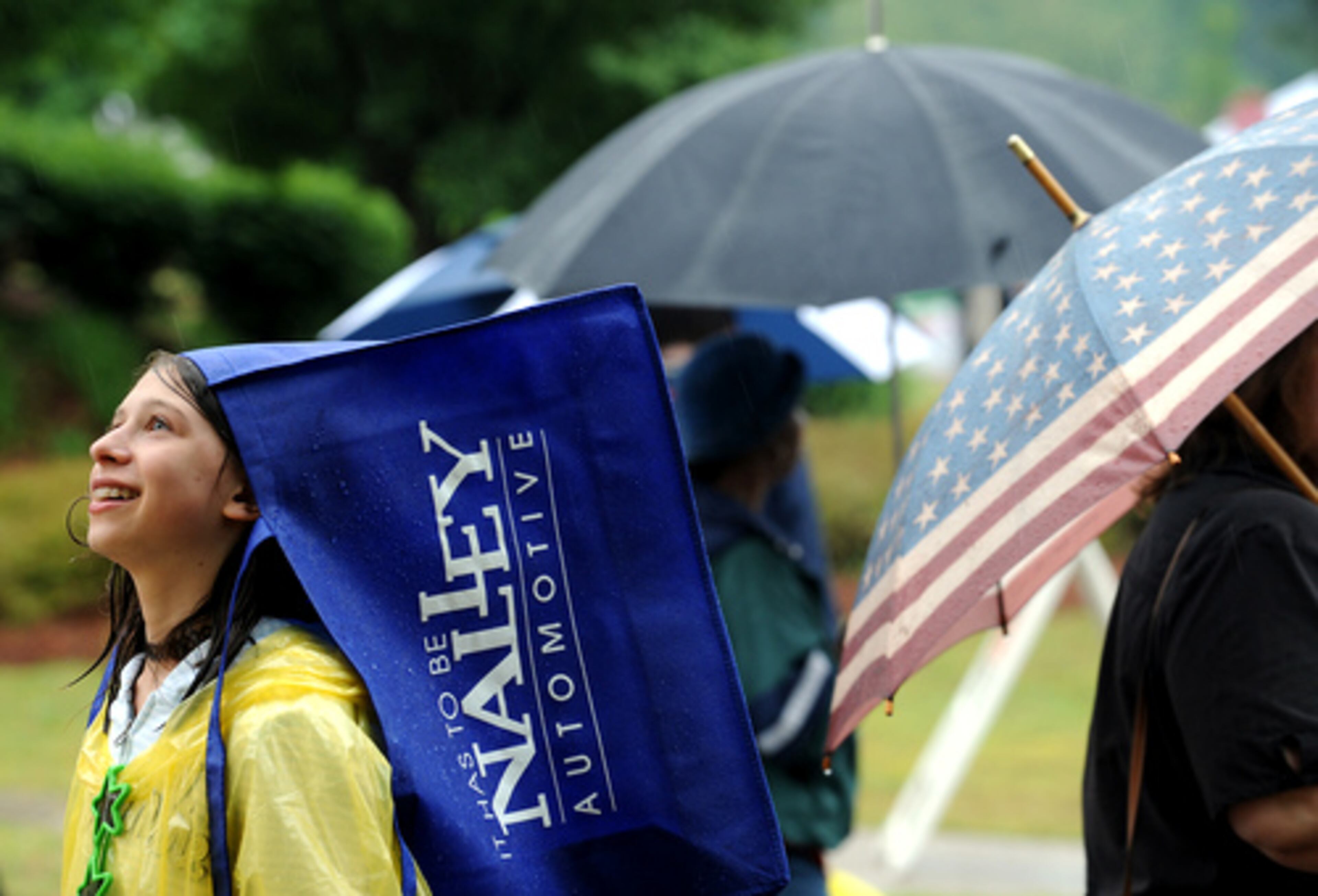Cayla Orris, 10, of Alpharetta uses a sponsors bag as a way to keep her head dry.