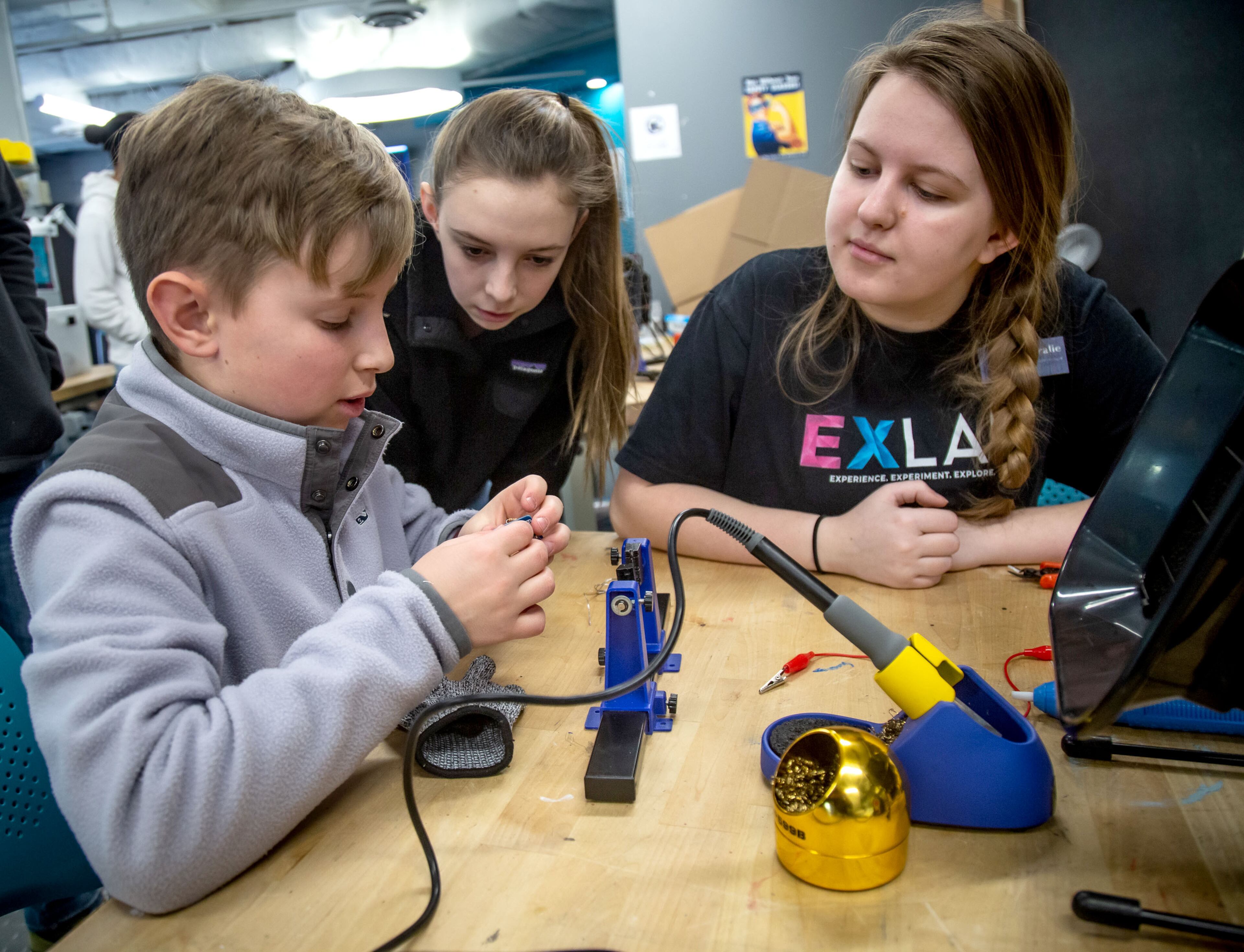Coralie Bergeron (R) helps Tommy Dunmire (L) with his soldering on a project he's working on during the Genius Camp in the ExLab at Georgia State University on Saturday, March 7, 2020. STEVE SCHAEFER / SPECIAL TO THE AJC