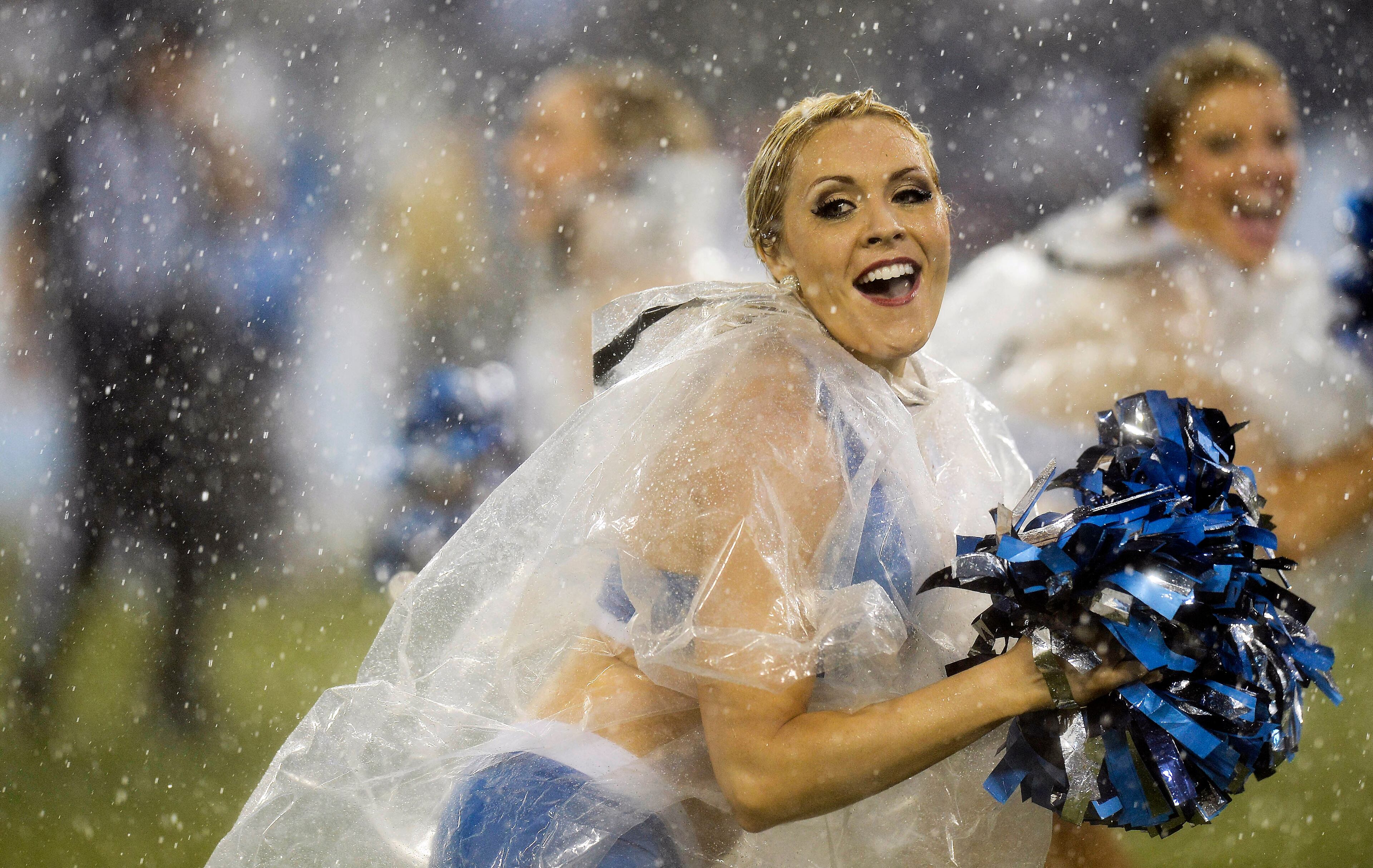 Tennessee Titans cheerleaders perform in the rain during the second quarter of a preseason NFL football game against the Green Bay Packers, Saturday, Aug. 9, 2014, in Nashville, Tenn. (AP Photo/Mark Zaleski)