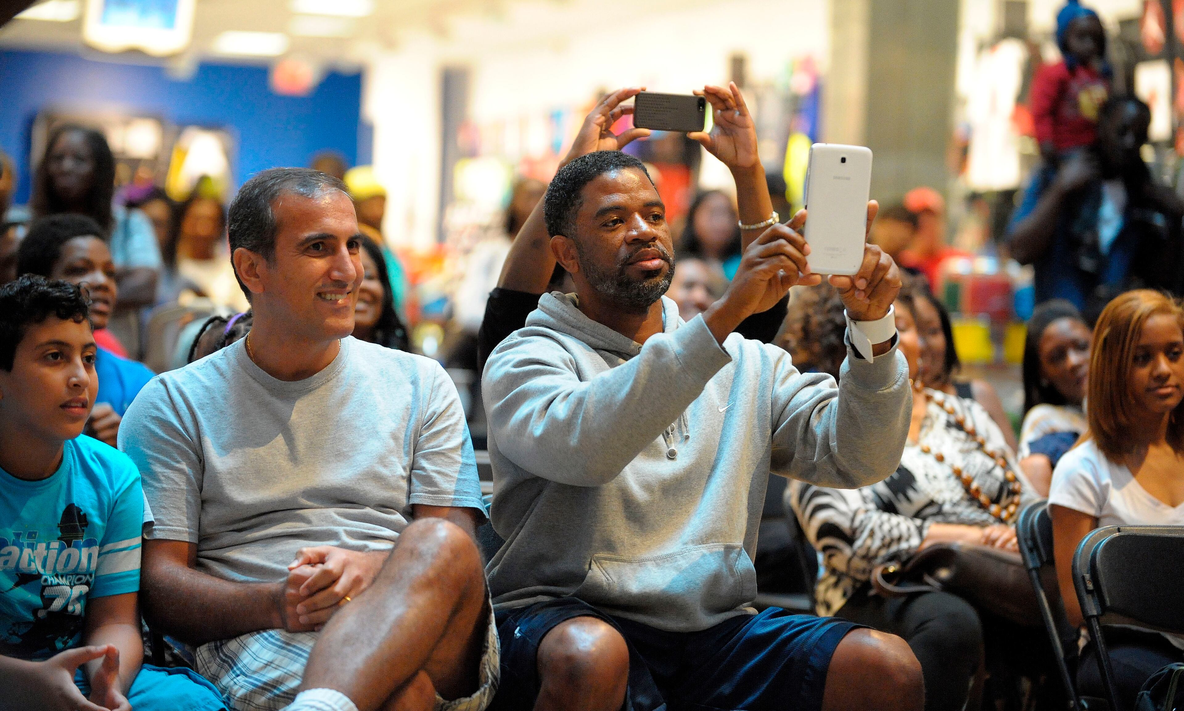 Viewers watch and snap photos as contestants perform a one-minute routine to the "Fast Man Remix" song during the Battle of the Year Dance Off at Stonecrest Mall on Aug. 17, 2013, in Lithonia.