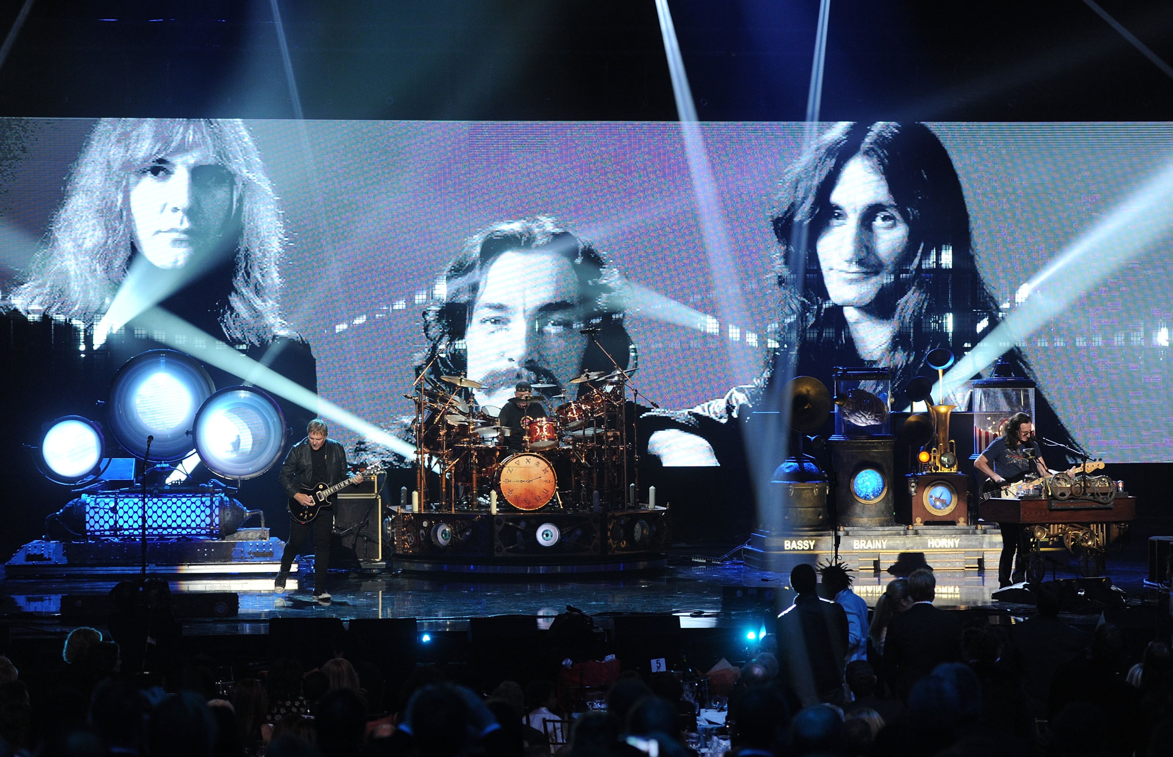 (L-R) Inductee Alex Lifeson, Neil Peart, and Geddy Lee of Rush perform on stage at the 28th Annual Rock and Roll Hall of Fame Induction Ceremony at Nokia Theatre L.A. Live on April 18, 2013 in Los Angeles, California. (Photo by Kevin Winter/Getty Images)