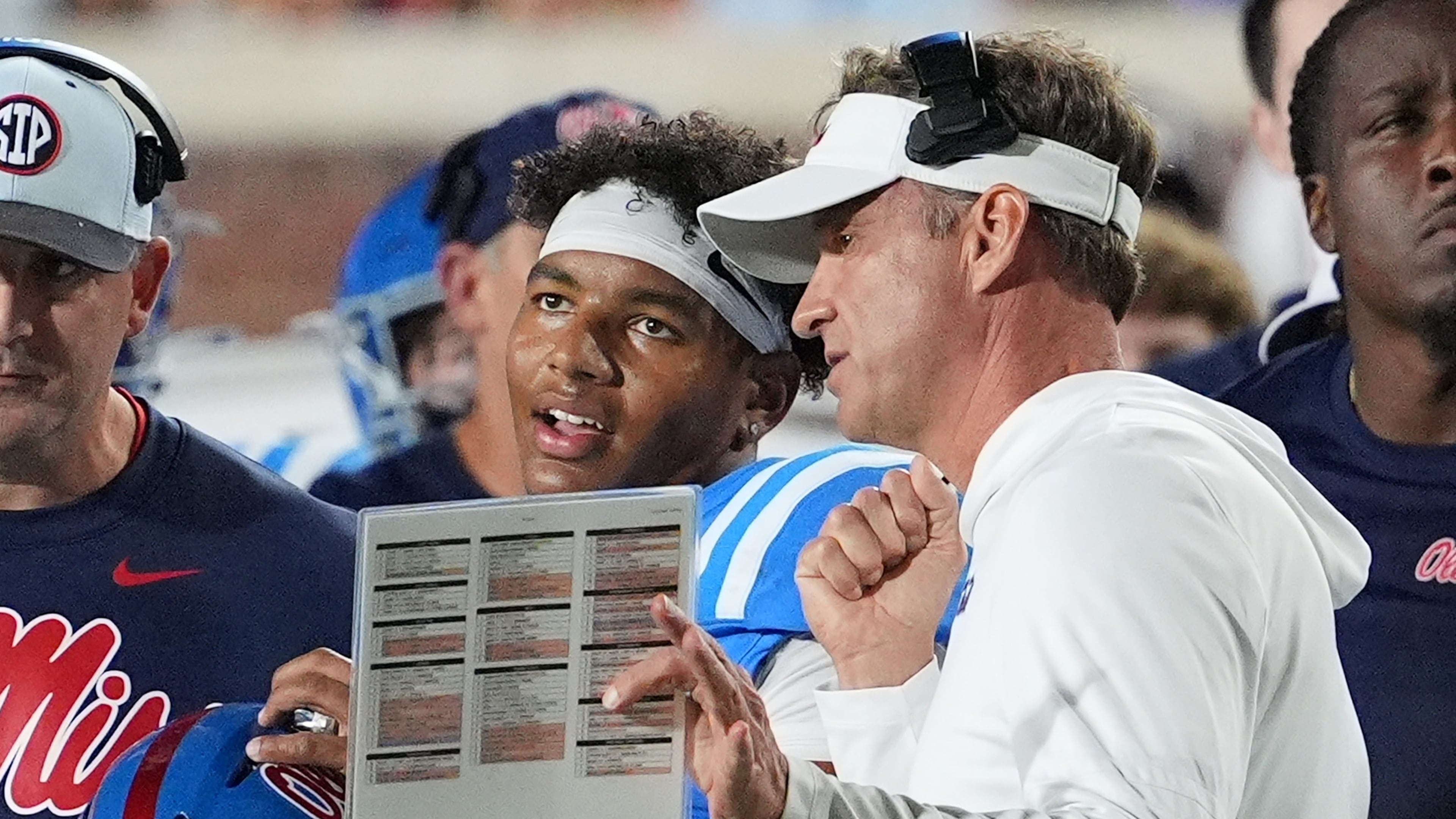 FILE - Mississippi head coach Lane Kiffin, center right, confers with quarterback Trinidad Chambliss, center left, during an NCAA college football game against Florida, Nov. 15, 2025, in Oxford, Miss. (AP Photo/Rogelio V. Solis, File)