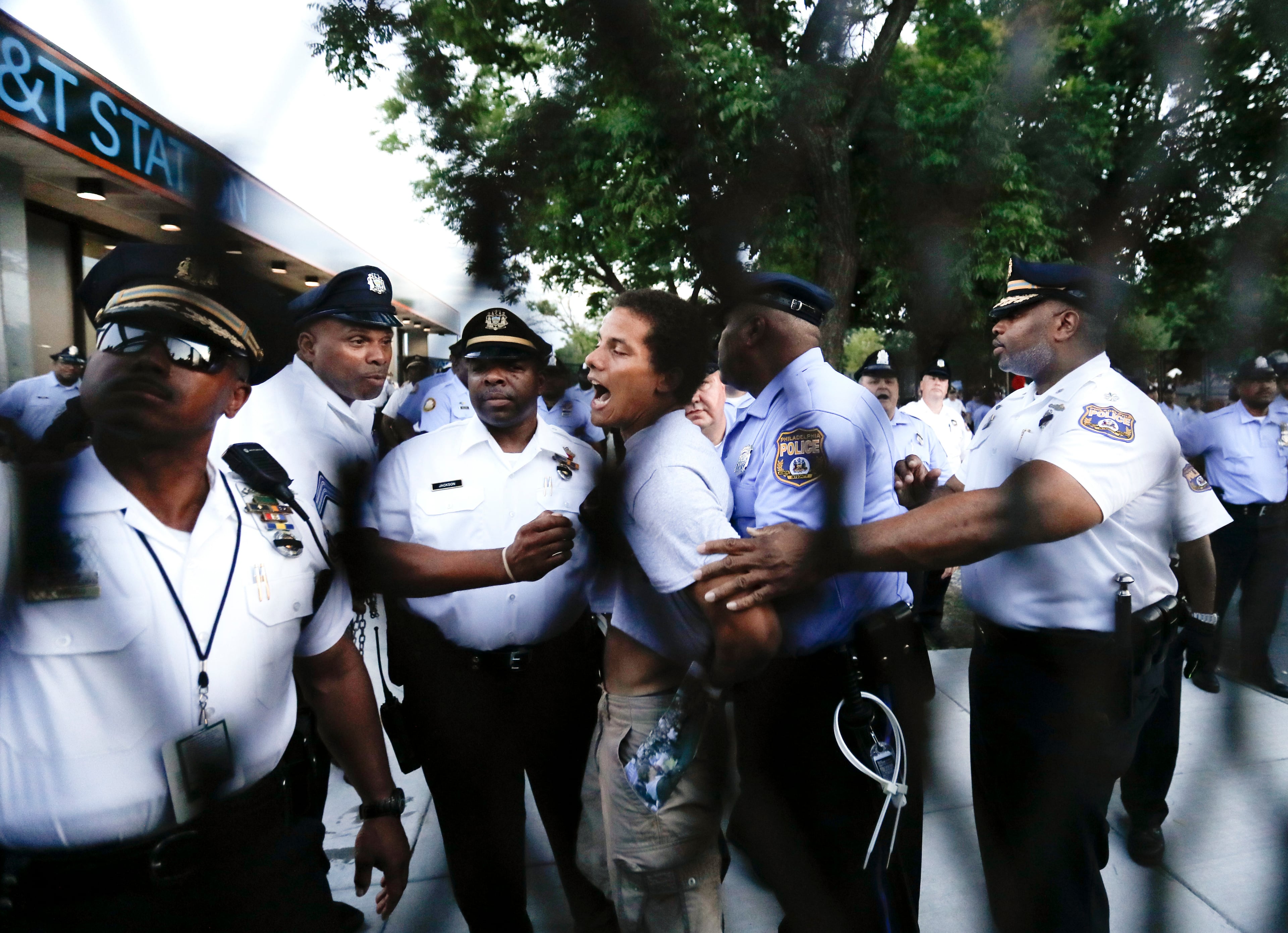 A demonstrator is taken into custody by police after climbing over a barricade near the AT&T Station in Philadelphia, Tuesday, July 26, 2016, during the second day of the Democratic National Convention. (AP Photo/Matt Slocum)