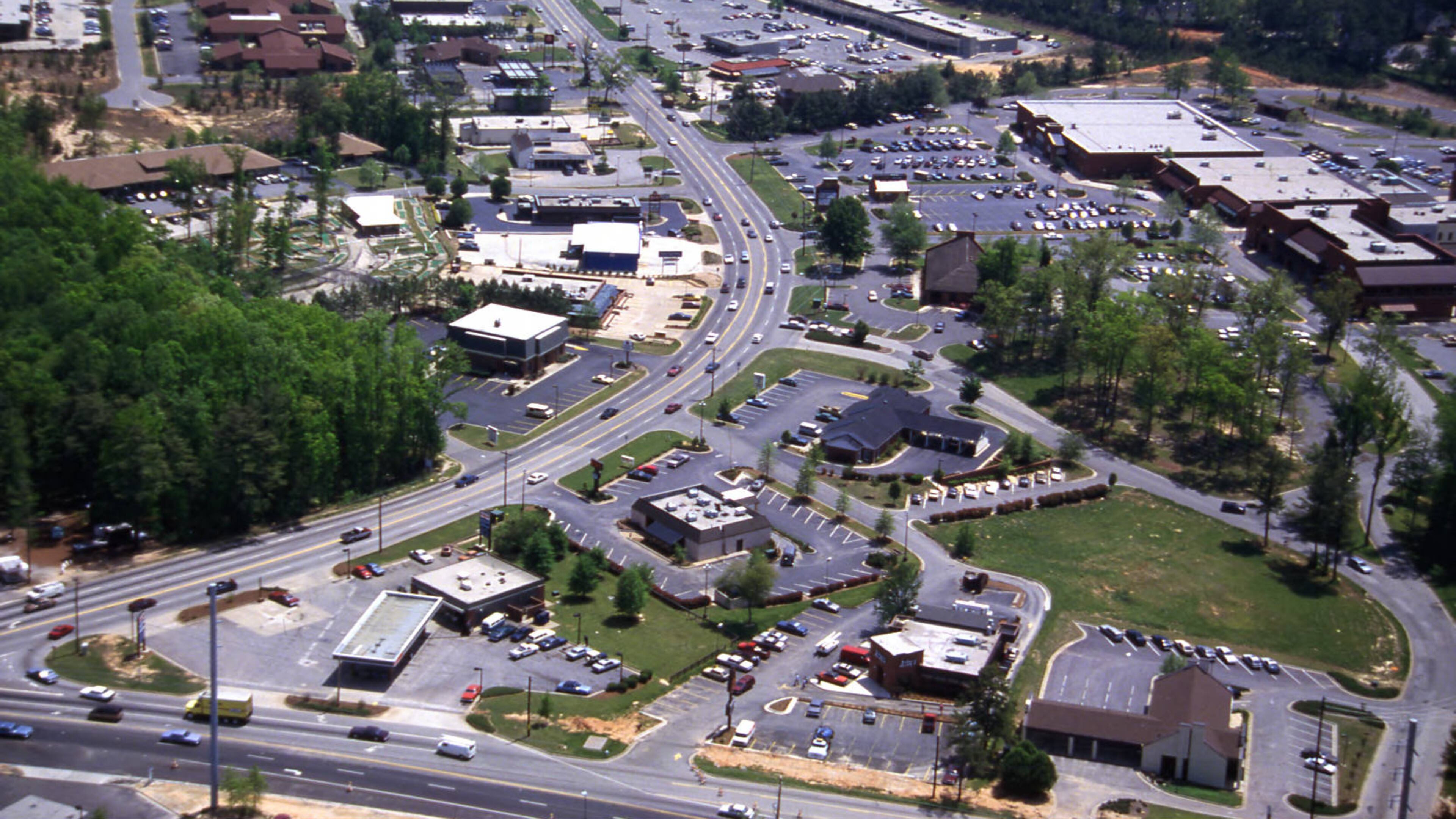 Aerial view of businesses along Johnson Ferry Road, looking southeast, Cobb County, Georgia, April 21, 1988. his has the intersection with GA 120 (Upper Roswell Rd) in foreground looking SE along JF. Merchants Walk is on the right side of the street." Photographer: Calvin Cruce.