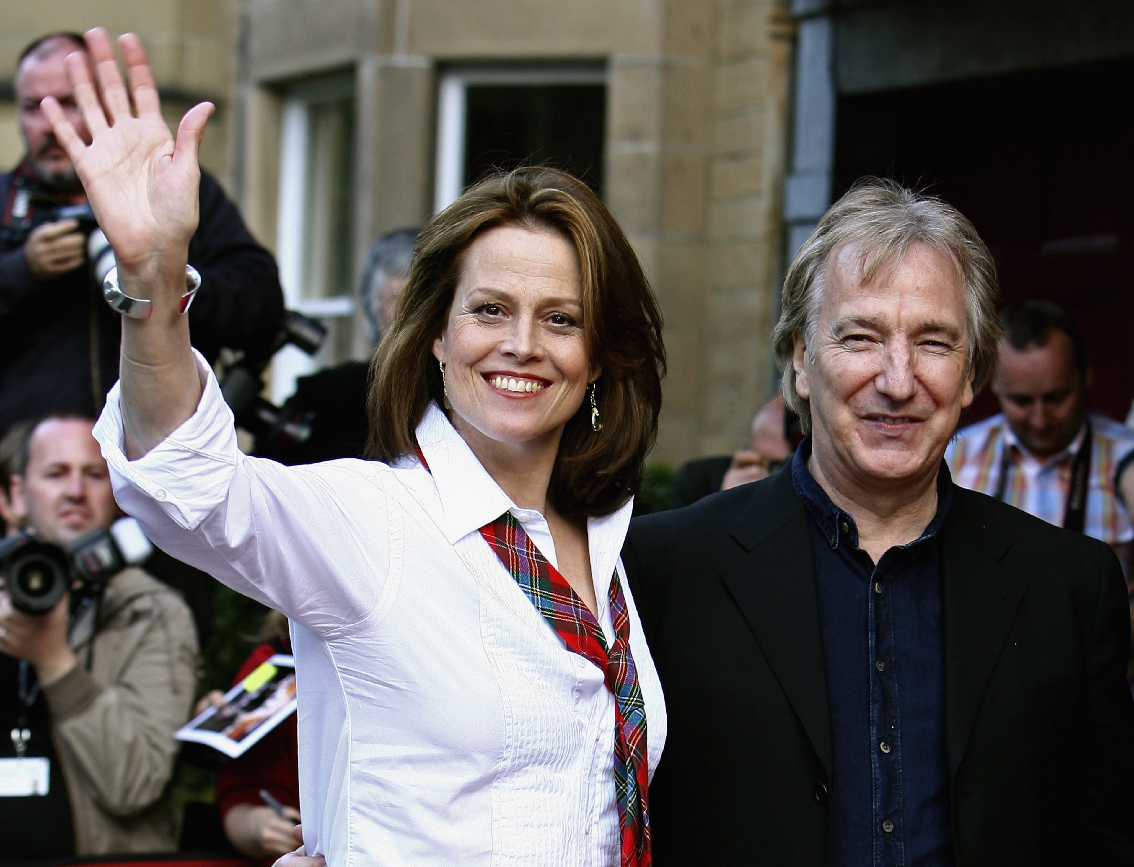 EDINBURGH, UNITED KINGDOM - AUGUST15: Actors Sigourney Weaver and Alan Rickman (R) wave as they arrive for the premier of the film "Snow Cake" at the Edinburgh International Film Festival, August 15, 2006 in Edinburgh, Scotland. (Photo by Jeff J Mitchell/Getty Images)