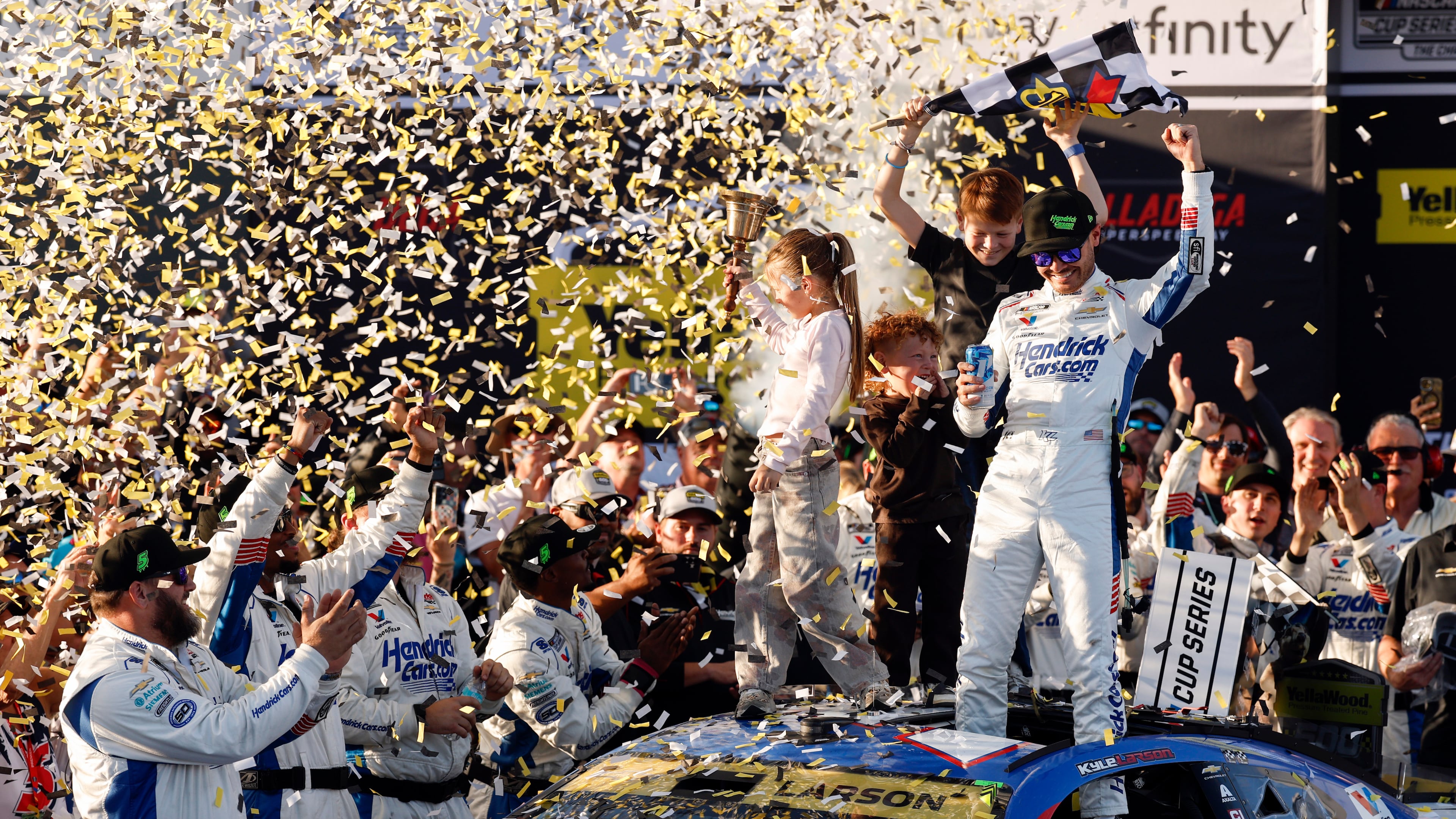 Kyle Larson, top right, celebrates with his children Owen, Audrey, and Cooper after his win in a NASCAR Cup Series auto race, Sunday, Oct. 25, 2026, in Talladega, Ala. (AP Photo/Butch Dill)