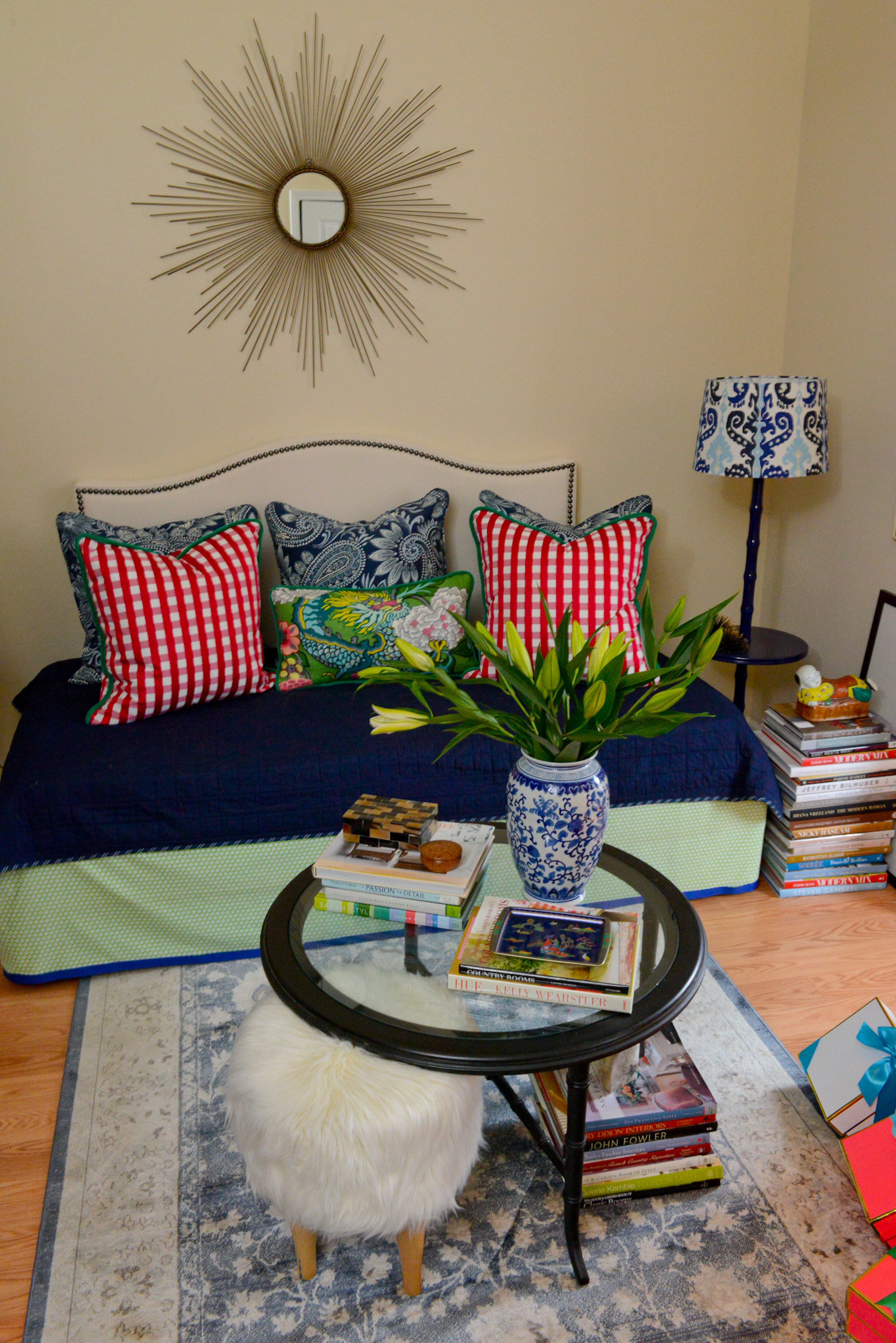 A custom upholstered daybed in the sitting room springs to life through homeowner and designer Travis Snyder's dynamic selection of patterns and color. Snyder found the sunburst mirror above the daybed at Wayfair.com. The shaggy footstool under the coffee table is from Target.