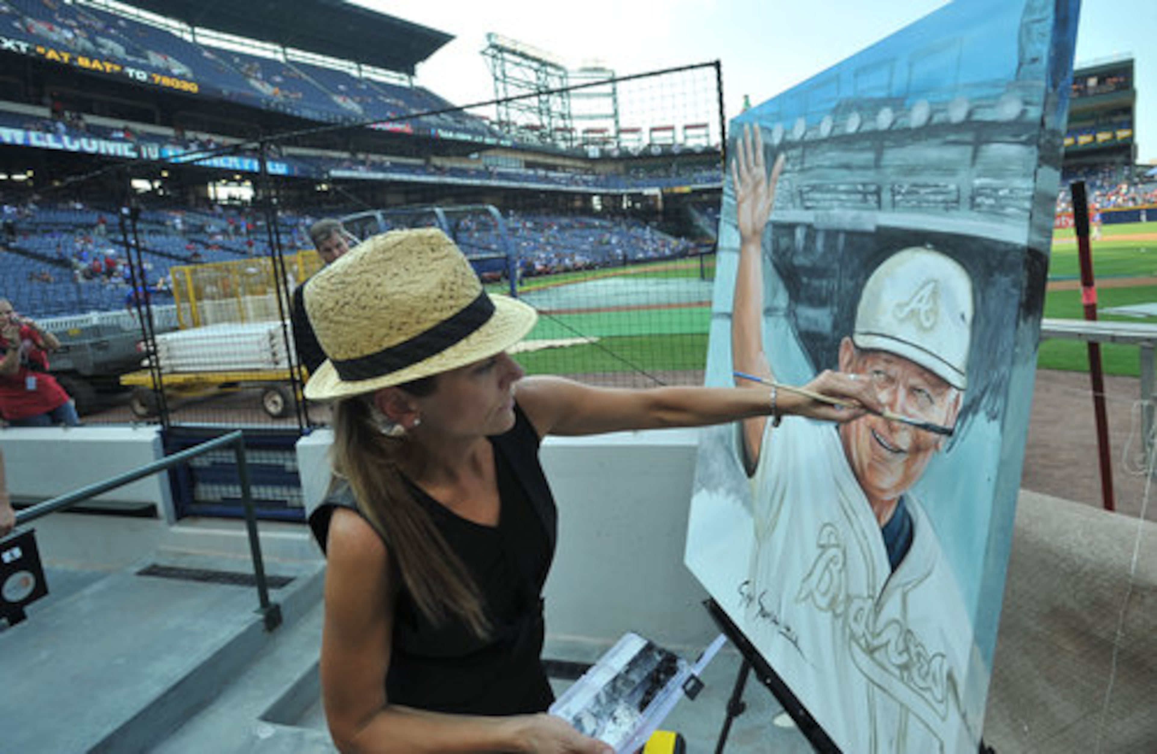 Susan Sommer Luarca works on painting Cox prior to the start of the event.