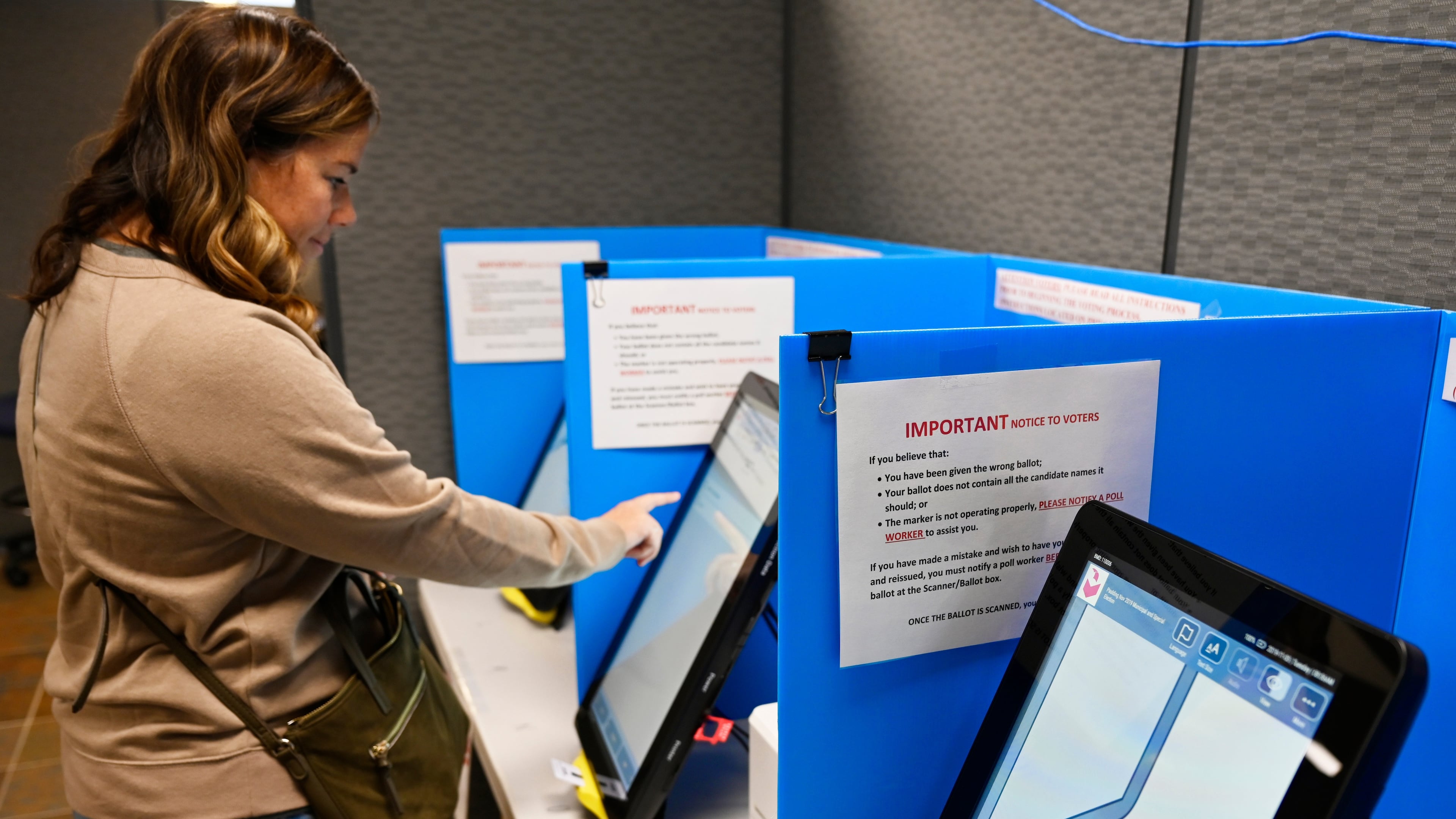 FILE- Courtney Parker votes on a new voting machine, in Dallas, Ga., Nov. 5, 2019. (AP Photo/Mike Stewart, File)