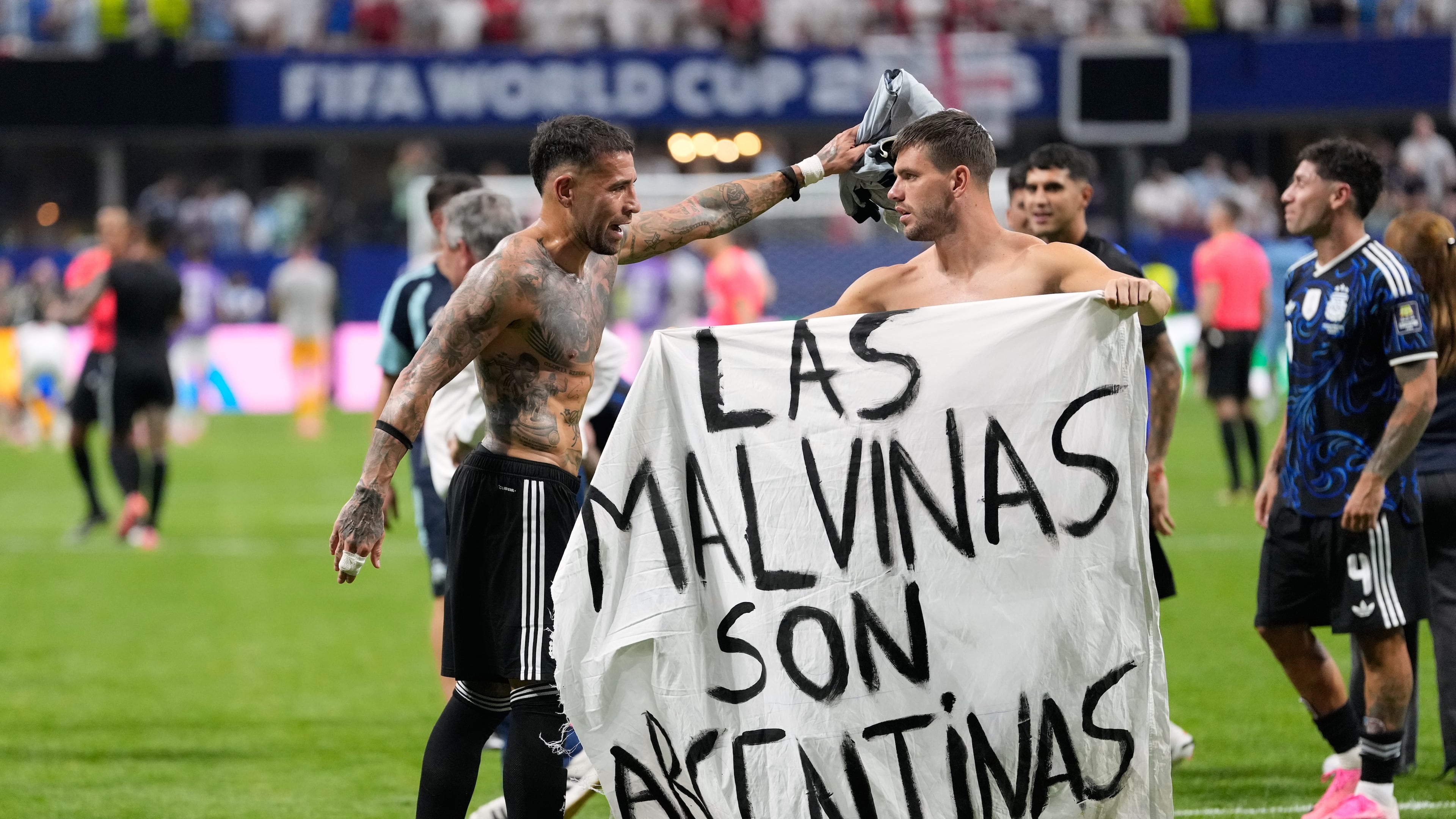 Argentina's Giovani Lo Celso holds a banner with the words "The Malvinas are Argentine", referring to the Falkland Islands, while teammate Argentina's Nicolas Otamendi gestures to him, at the end of the World Cup semifinal soccer match between England and Argentina in Atlanta, Wednesday, July 15, 2026. (AP Photo/Rebecca Blackwell)