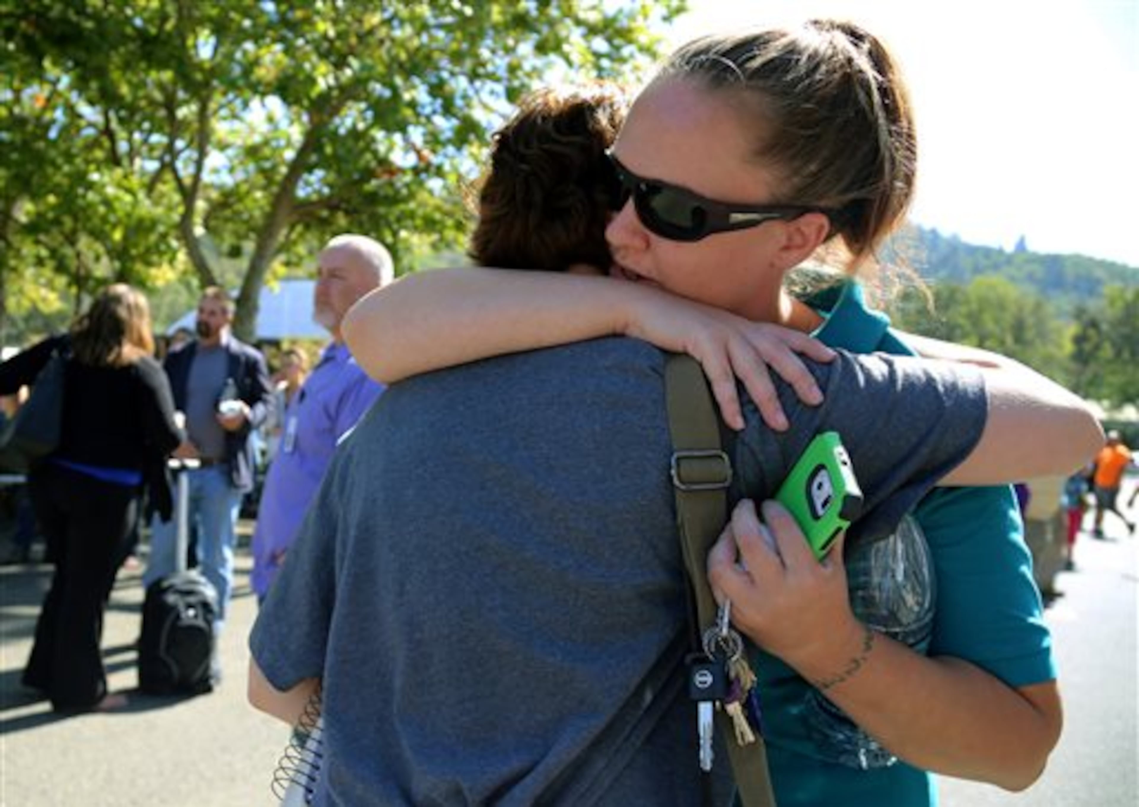 Click on this link for updates on the Oregon school shooting. A woman is comforted as friends and family wait for students at the local fairgrounds after a shooting at Umpqua Community College in Roseburg, Ore., on Thursday, Oct. 1, 2015. (AP Photo/Ryan Kang)