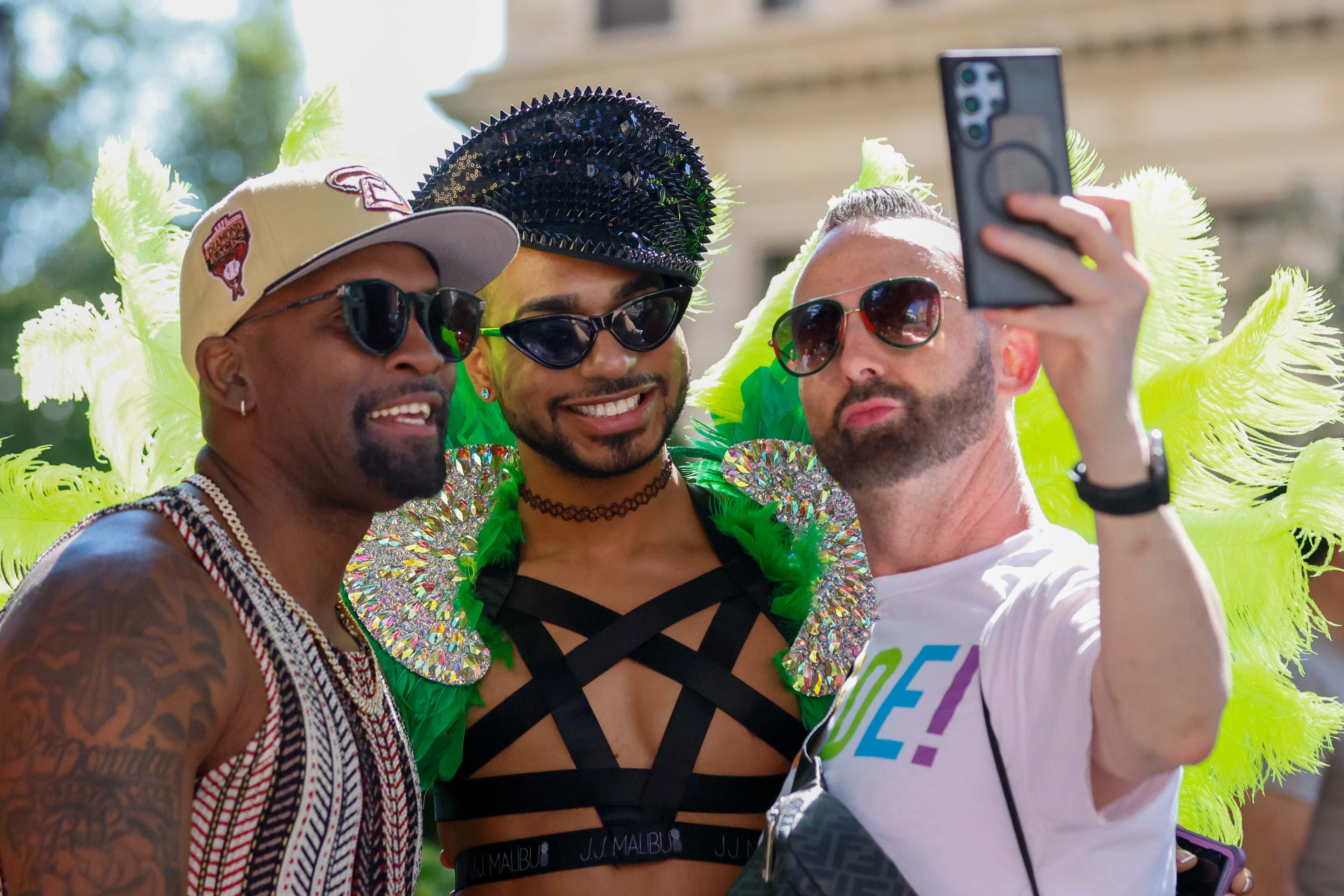 Phillip Headrick takes a cellphone photo with Anrwan Dennis and Asa Jordan (center) during the annual Pride Parade in Atlanta on Sunday, Oct. 13, 2024.
(Miguel Martinez / AJC)