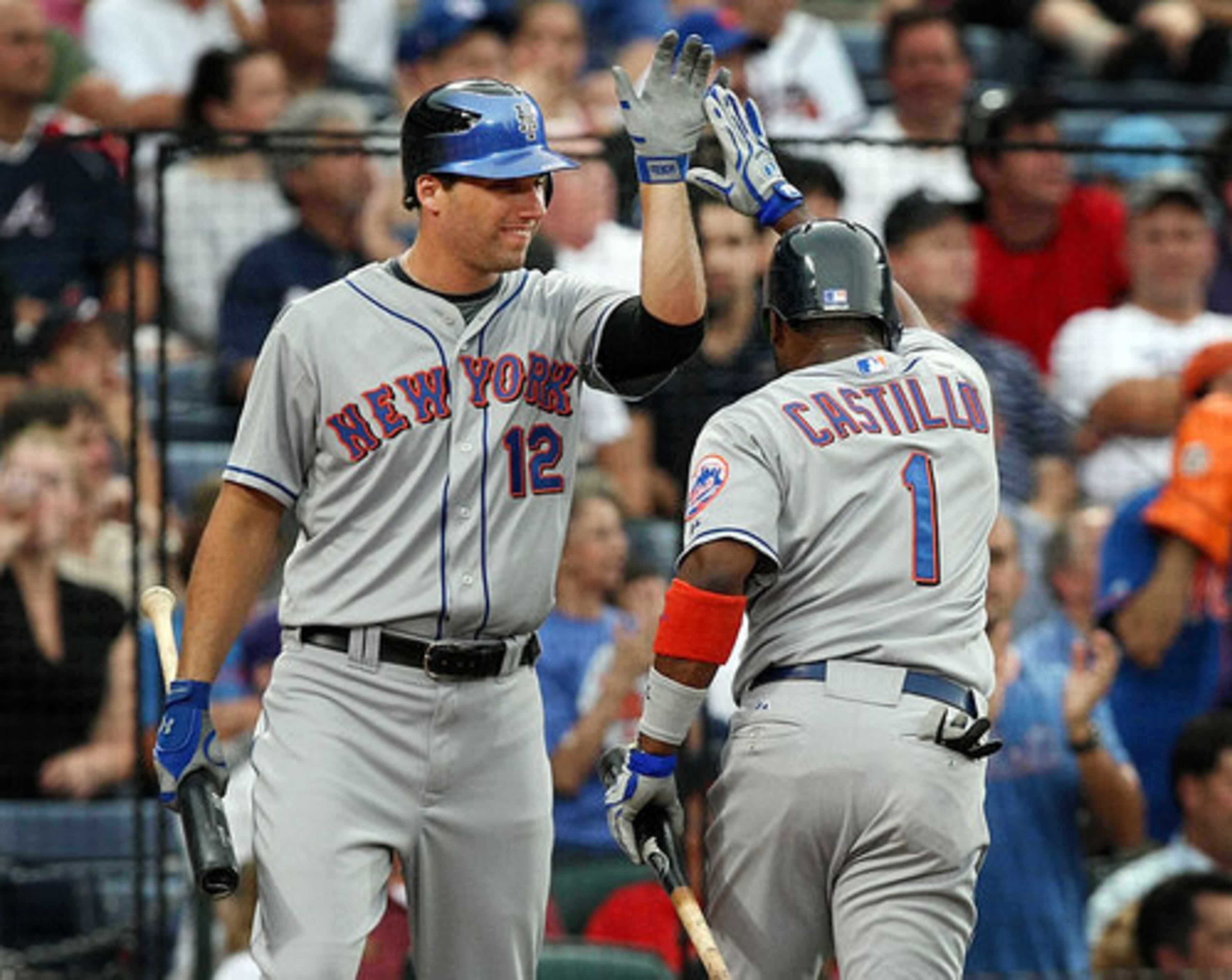 Francoeur gives Luis Castillo a high five as he scores on a single.
