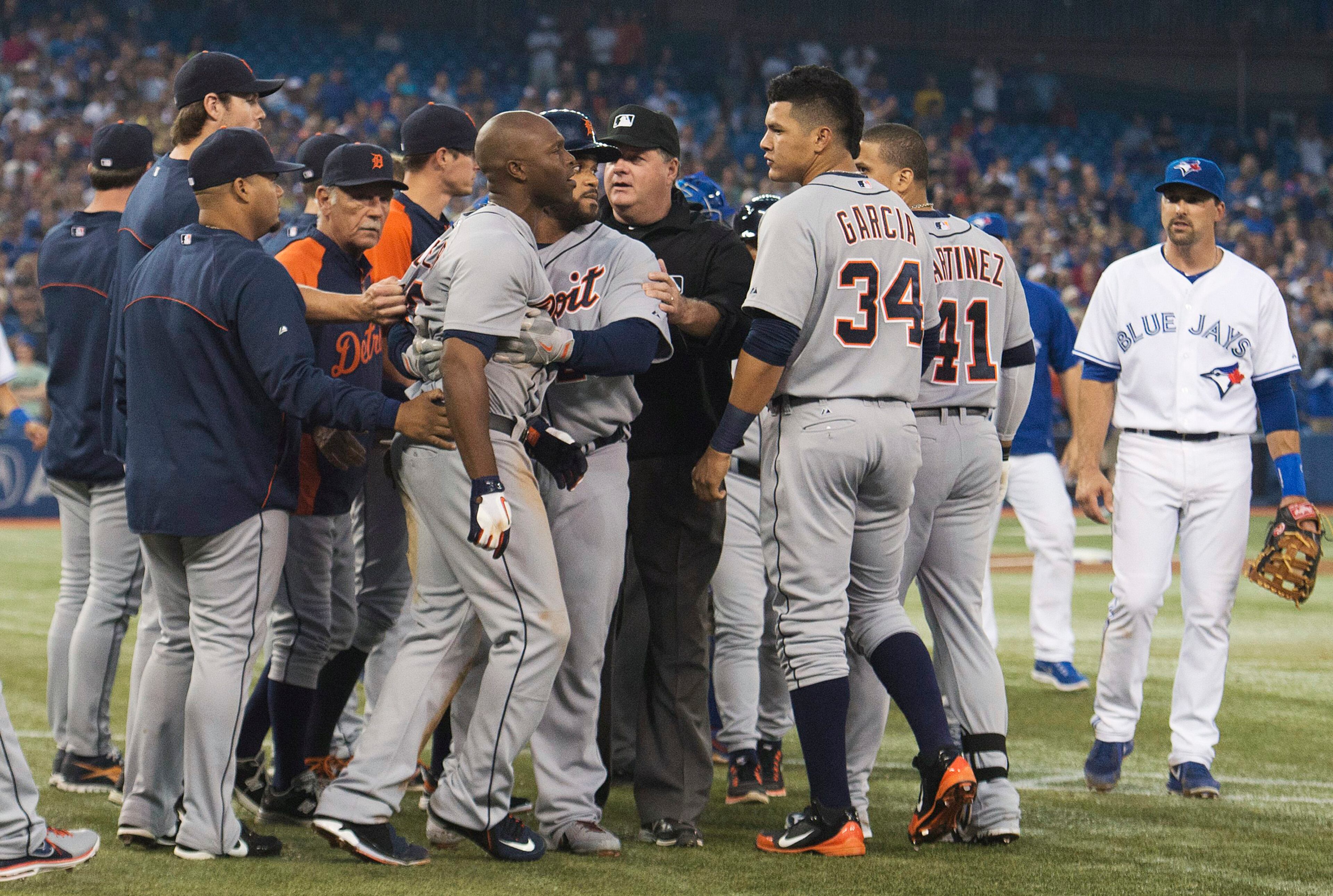 Detroit Tigers' Torii Hunter, center left, is held back by teammates after Hunter was hit by a pitch from Toronto Blue Jays pitcher Todd Redmond during the sixth inning of a baseball game Wednesday, July 3, 2013, in Toronto. (AP Photo/The Canadian Press, Nathan Denette)