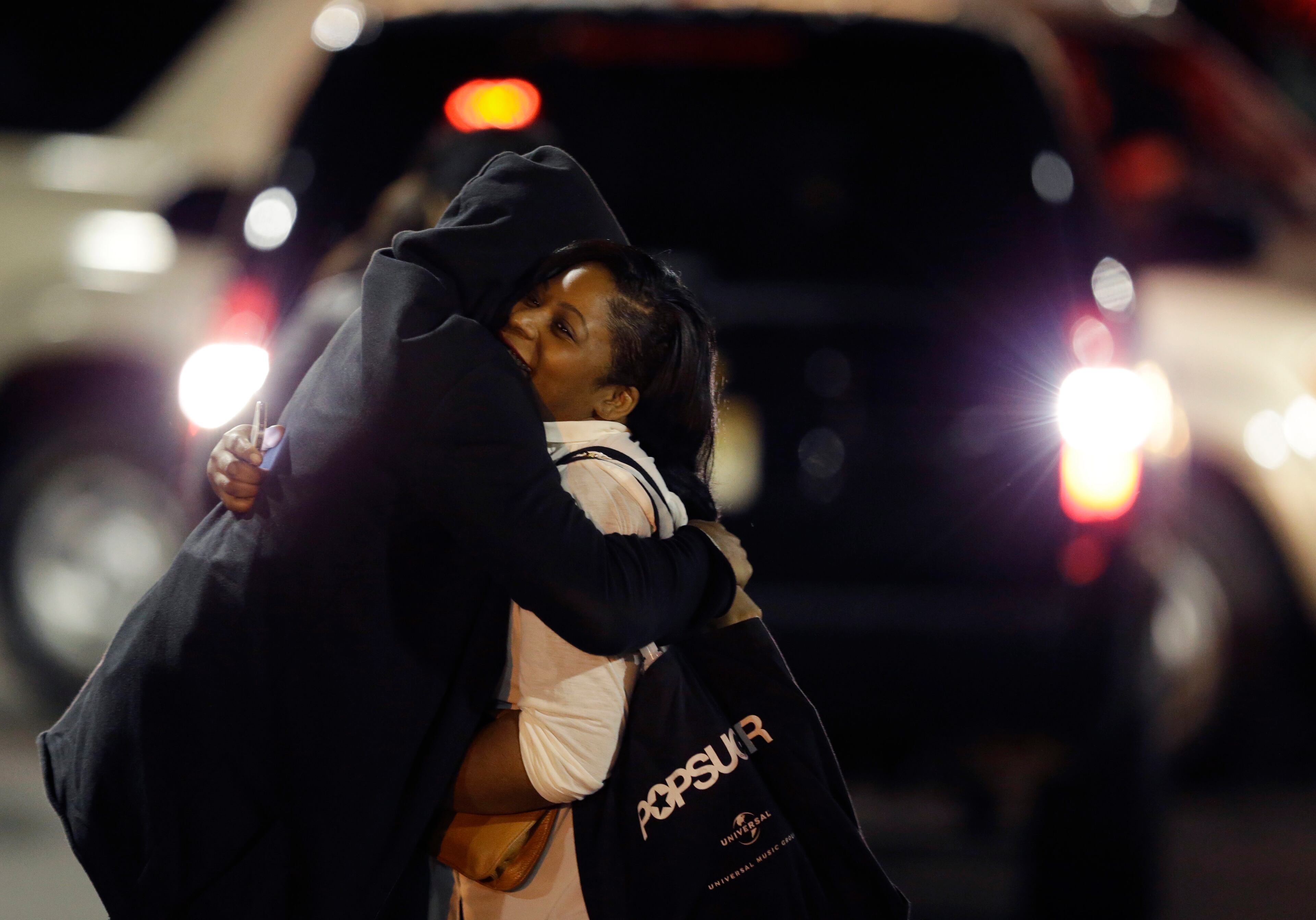A woman, right, is reunited with a man in the parking lot of Garden State Plaza Mall following reports of a shooter, Tuesday, Nov. 5, 2013, in Paramus, N.J. Hundreds of law enforcement officers converged on the mall Monday night after witnesses said multiple shots were fired there. (AP Photo/Julio Cortez)