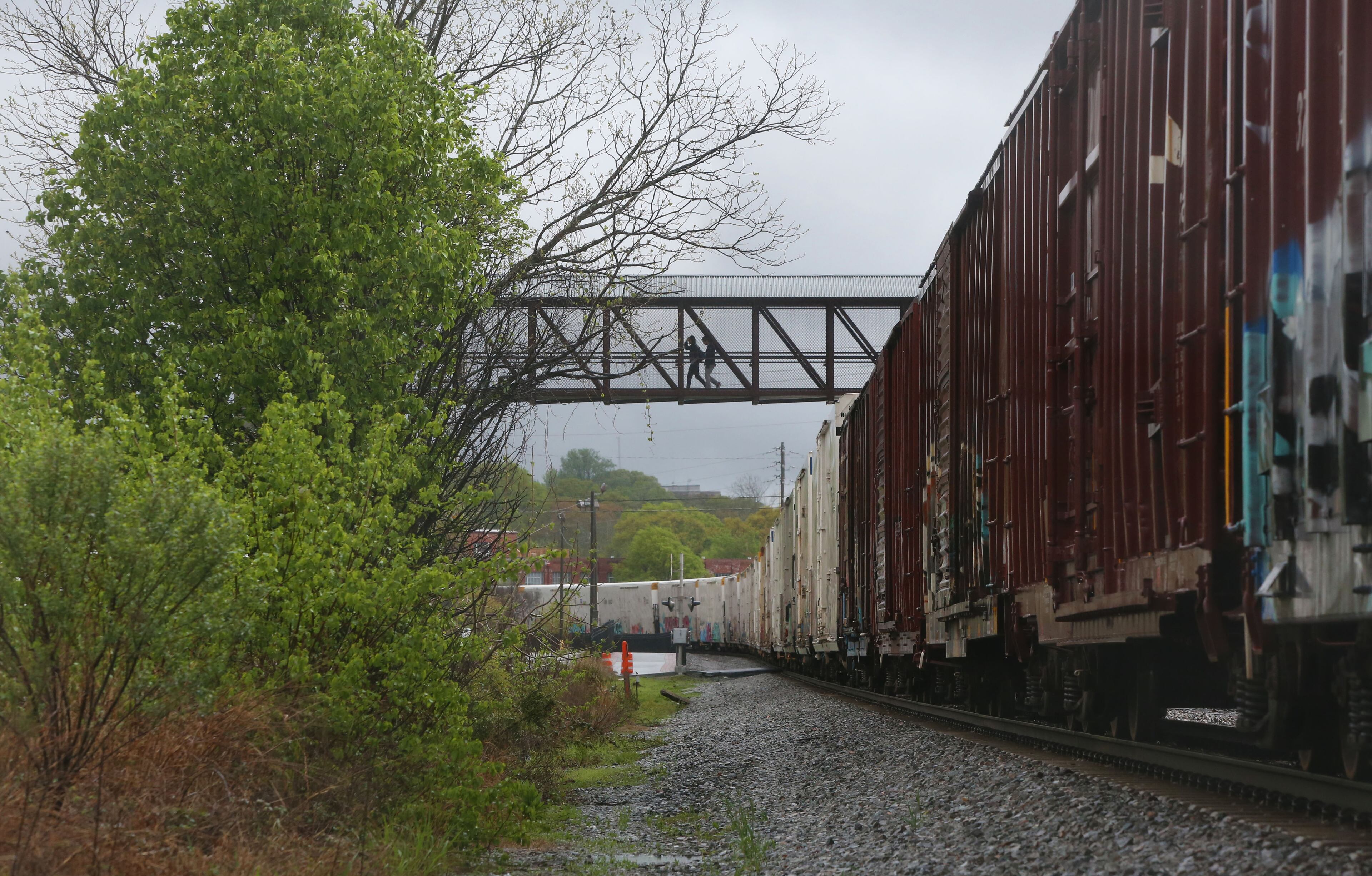 April 5, 2017, Atlanta, Georgia - Pedestrians use the bridge to cross the train tracks outside of the downtown area where a train came to a stop for nearly half an hour in Marietta, Georgia, on April 5, 2017. (HENRY TAYLOR / HENRY.TAYLOR@AJC.COM)