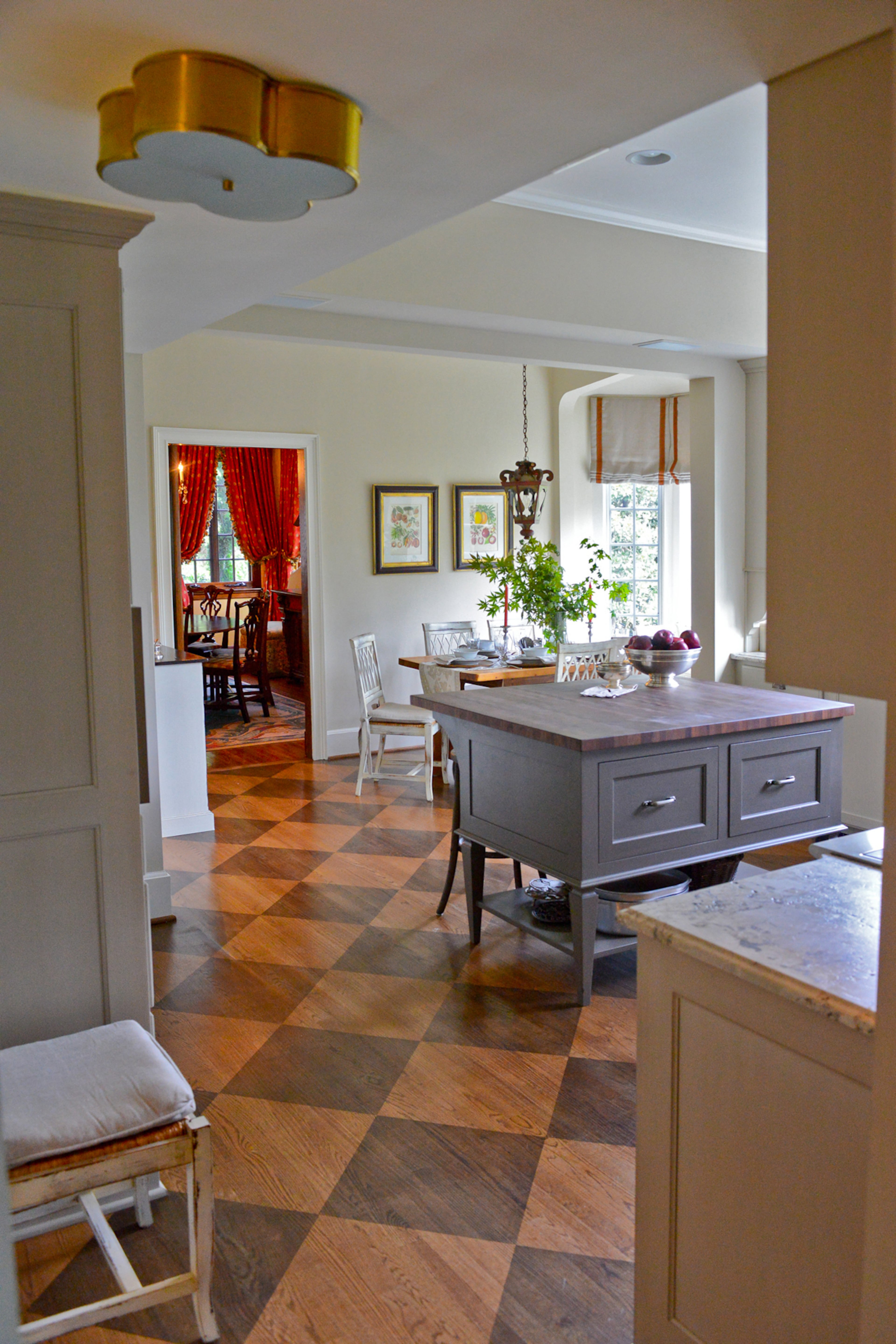The J. Tribble custom walnut butcher block island is the centerpiece of Danielle Nix's newly renovated kitchen. Sconces, along with the clover ceiling light fixture in the kitchen, are from Circa Lighting. The addition of a new kitchen pantry gives the century-old kitchen plenty of storage.