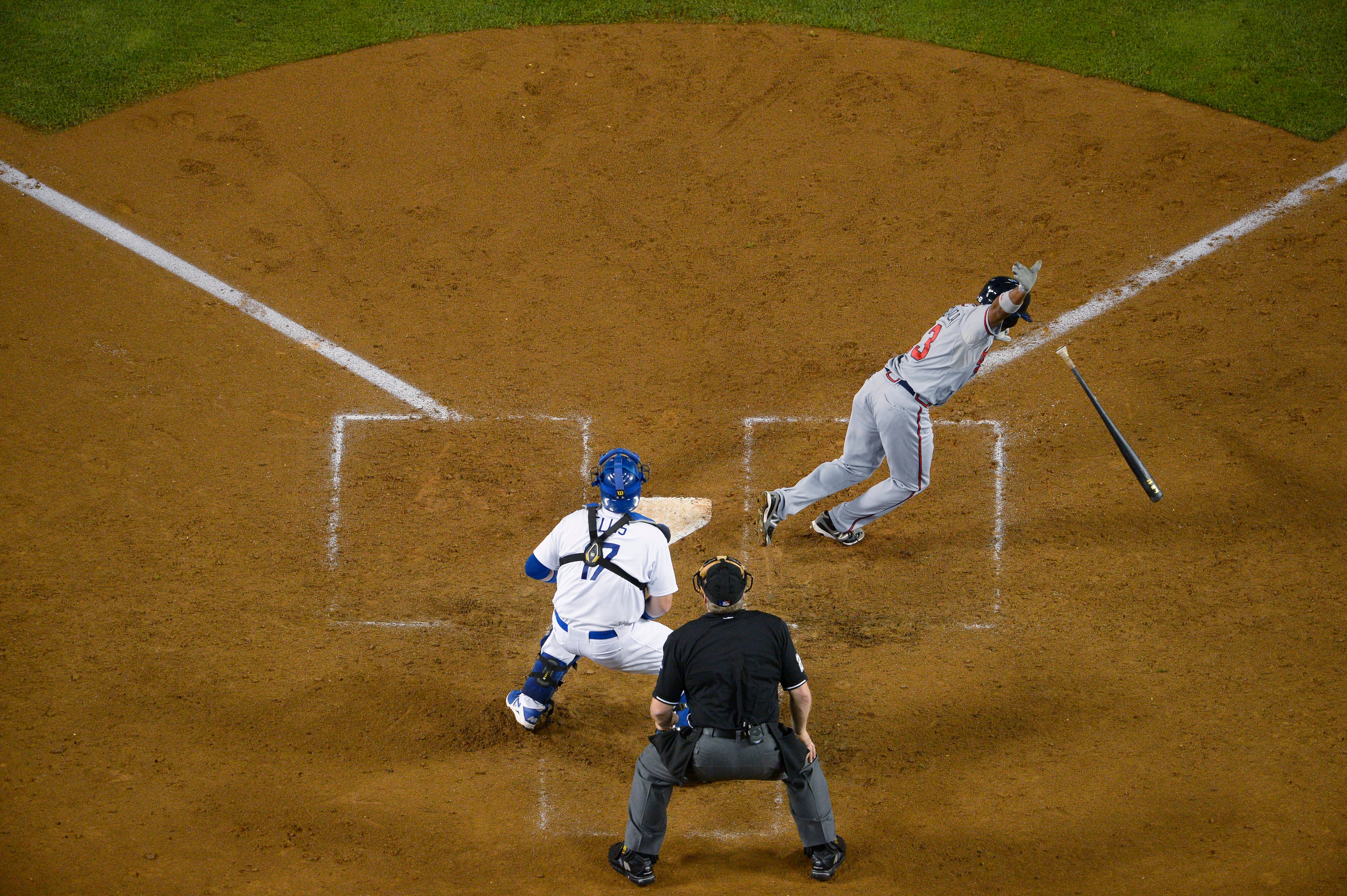 Atlanta Braves' Jose Constanza, right, tosses his bat after hitting a single in the seventh inning to score Elliot Johnson, as Los Angeles Dodgers catcher A.J. Ellis and home plate umpire Bill Miller stand behind the plate, in Game 4 of the National League division baseball series Monday, Oct. 7, 2013, in Los Angeles. (AP Photo/Mark J. Terrill)