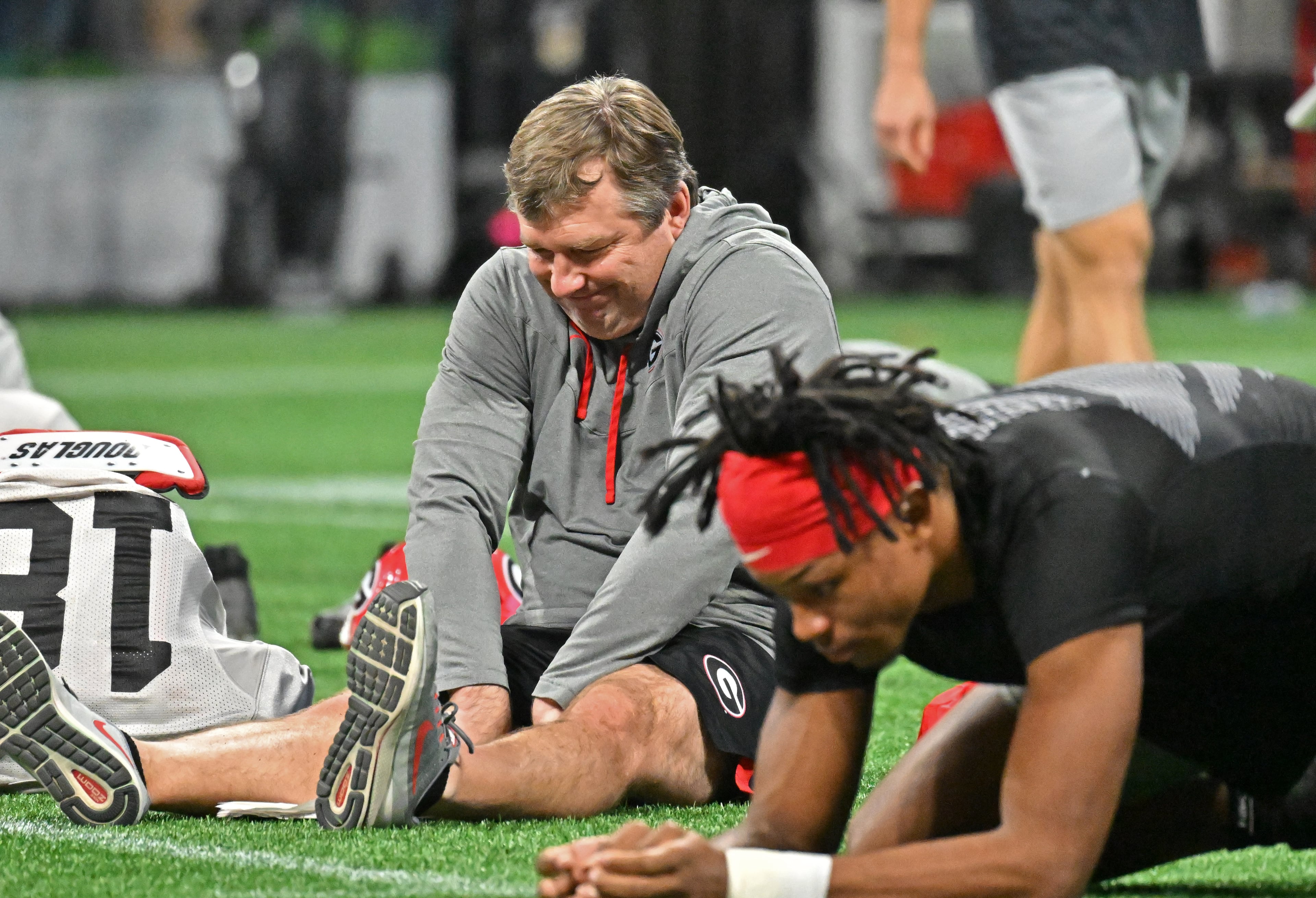 Georgia's head coach Kirby Smart stretches too as players get loose during a practice session for the Chick-fil-A Peach Bowl game against Ohio State at the Mercedes-Benz Stadium on Thursday, Dec. 29, 2022, in Atlanta. (Hyosub Shin / Hyosub.Shin@ajc.com)
