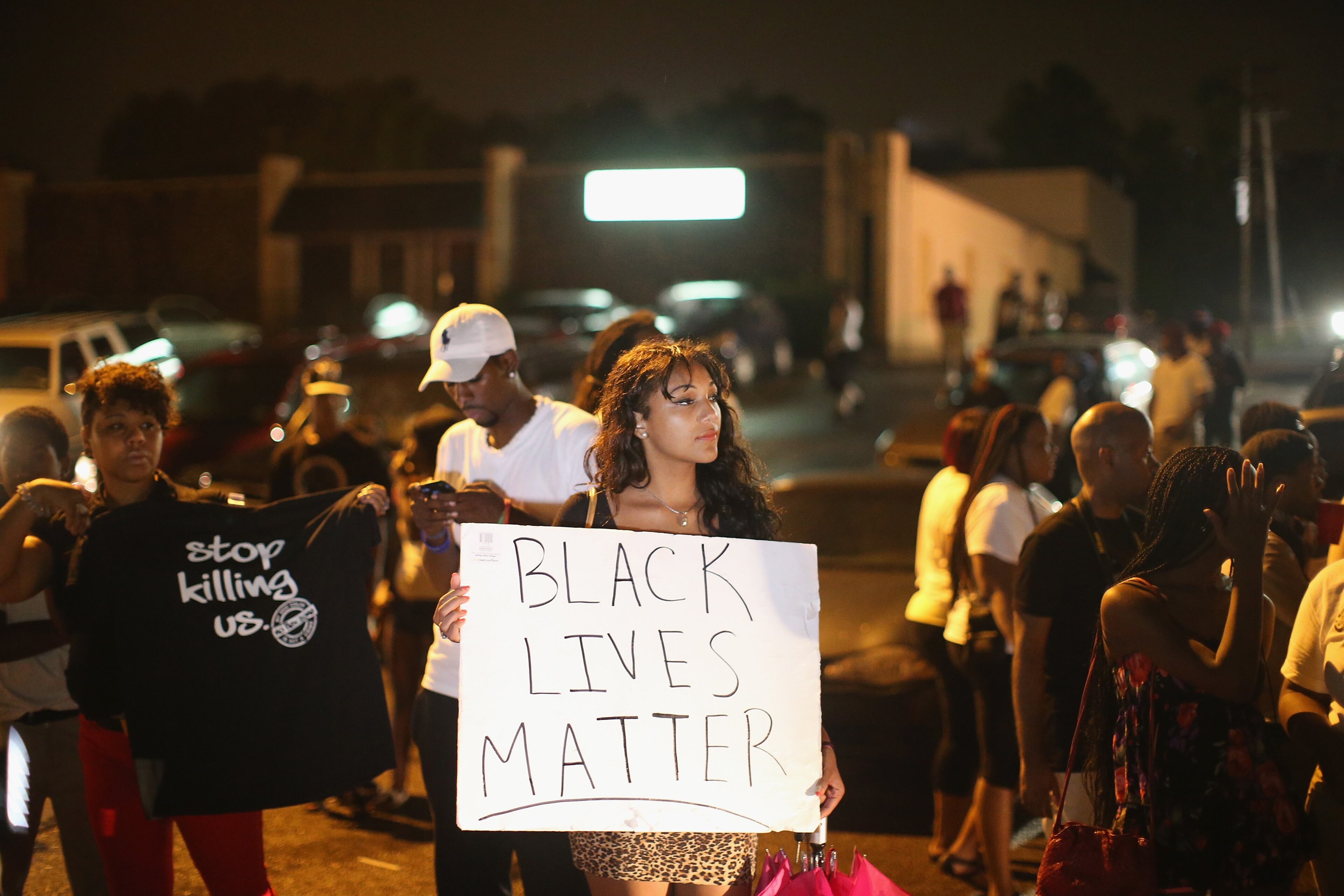FERGUSON, MO - AUGUST 15: Demonstrators gather along West Florissant Avenue to protest the shooting of Michael Brown on August 15, 2014 in Ferguson, Missouri. Brown was shot and killed by a Ferguson police officer on August 9. Tonight's demonstration again ended with protestors clashing with police followed by more looting. (Photo by Scott Olson/Getty Images)