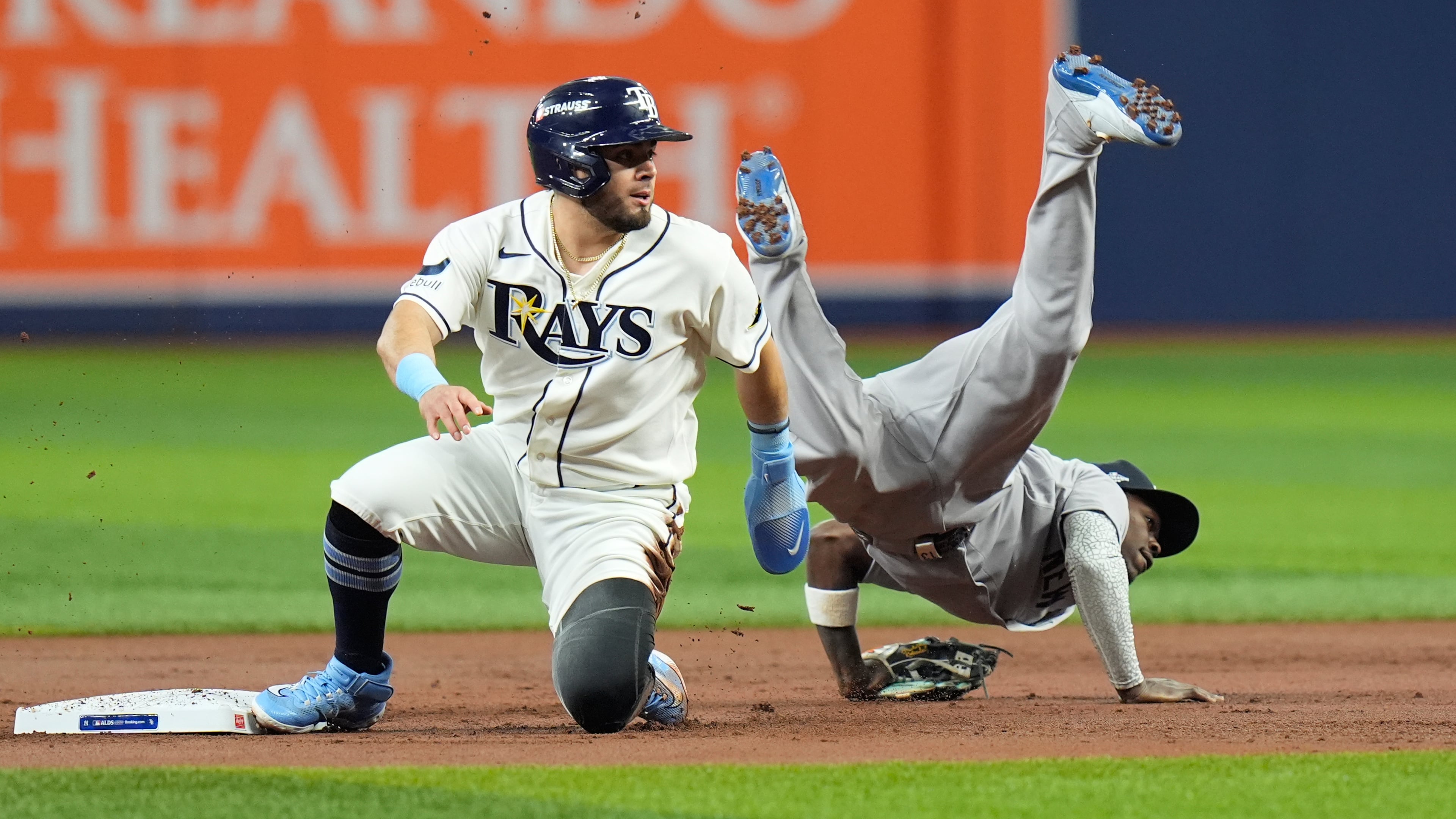 New York Yankees second baseman Jazz Chisholm Jr., right, flips over Tampa Bay Rays' Jonathan Aranda, left, while committing a throwing error allowing Rays' Yandy Díaz to score during the first inning in Game 2 of an American League Division Series baseball game Monday, Oct. 5, 2026, in St. Petersburg, Fla. (AP Photo/Chris O'Meara)