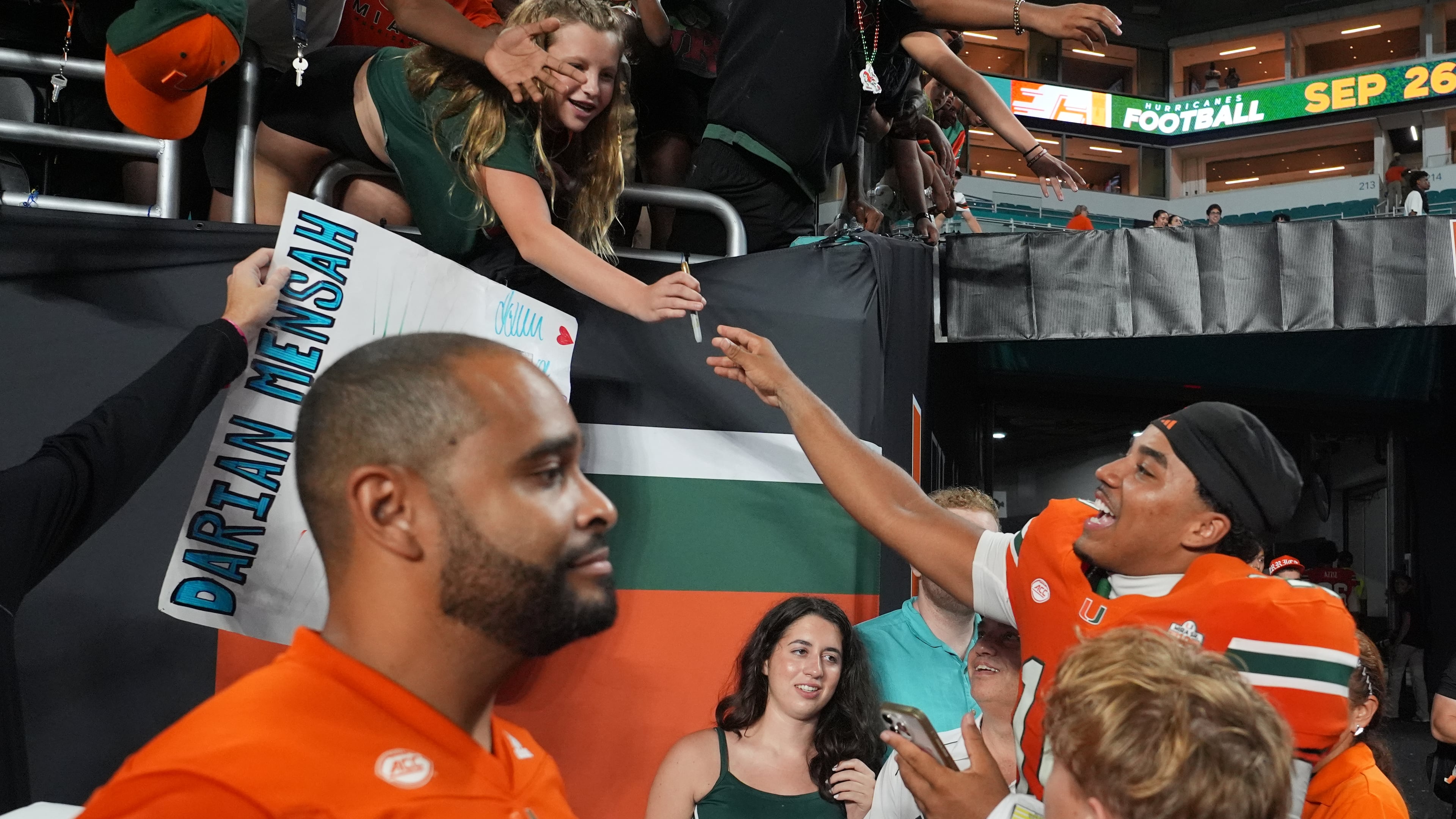 Miami quarterback Darian Mensah, right, signs autographs after an NCAA college football game against Florida A&M, Thursday, Sept. 10, 2026, in Miami Gardens, Fla. (AP Photo/Lynne Sladky)
