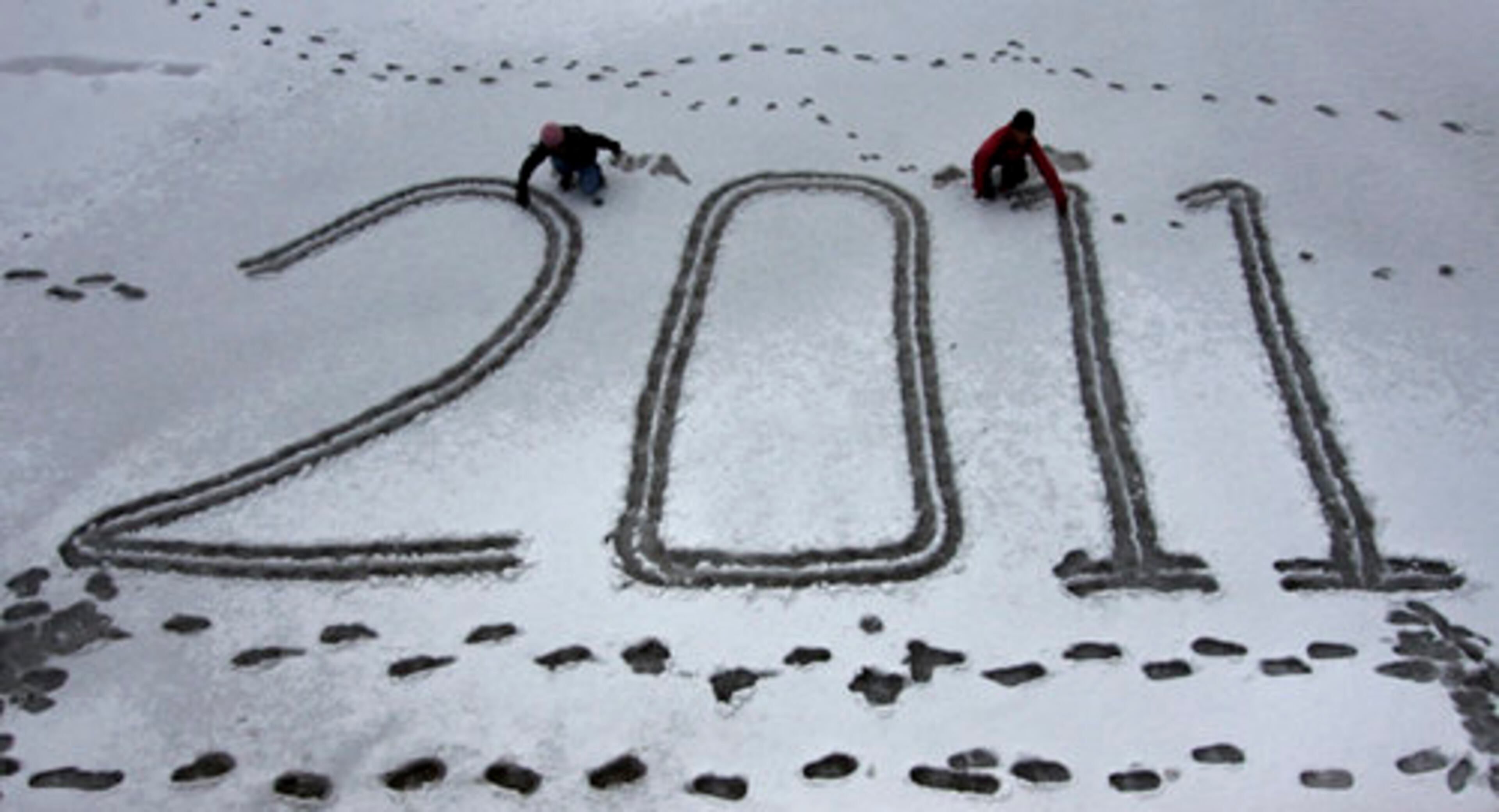 Children write 2011 on a snow covered field in Shimla, India, as midnight approaches.