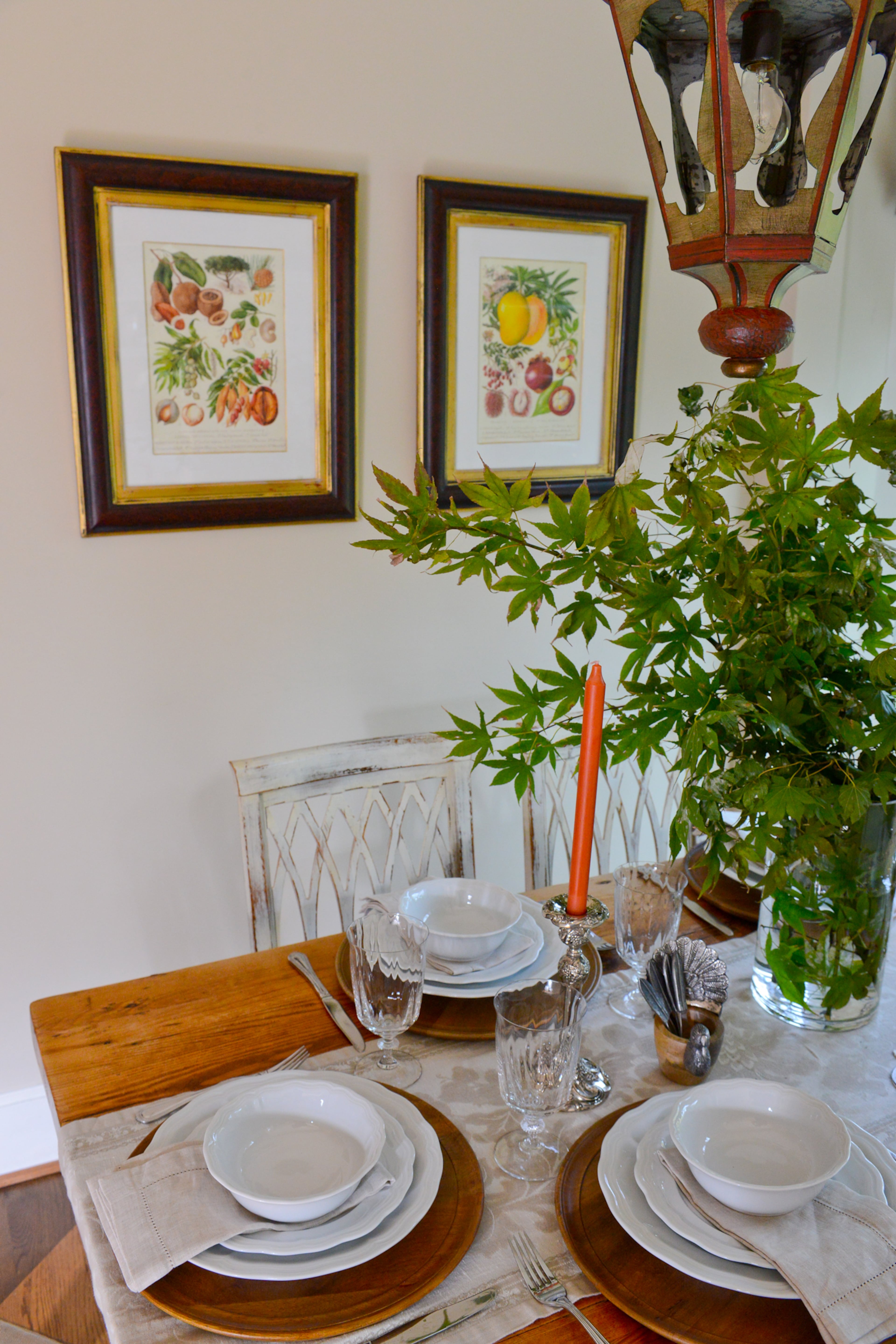 A table setting of wood chargers and white plates amid bouquets of greenery add to the fresh feel of the renovated 110-year-old East Lake home.