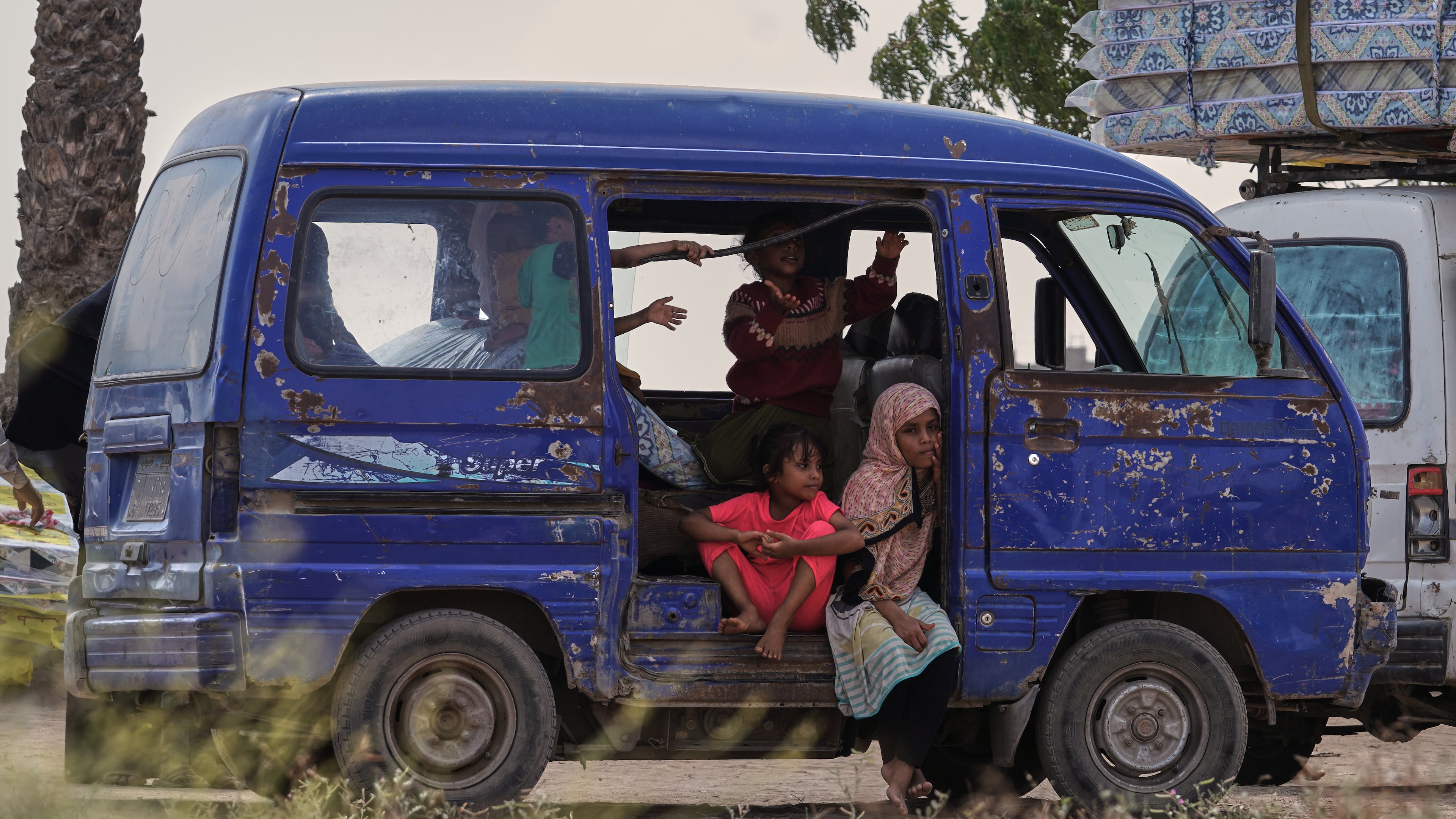 Displaced Yemeni children sit in a vehicle as families gather to receive aid at the Al-Fallahine displacement camp in Dar Saad district, Aden, Yemen, Monday, Oct. 12, 2026. (AP Photo/Abdulnasser Alseddik)